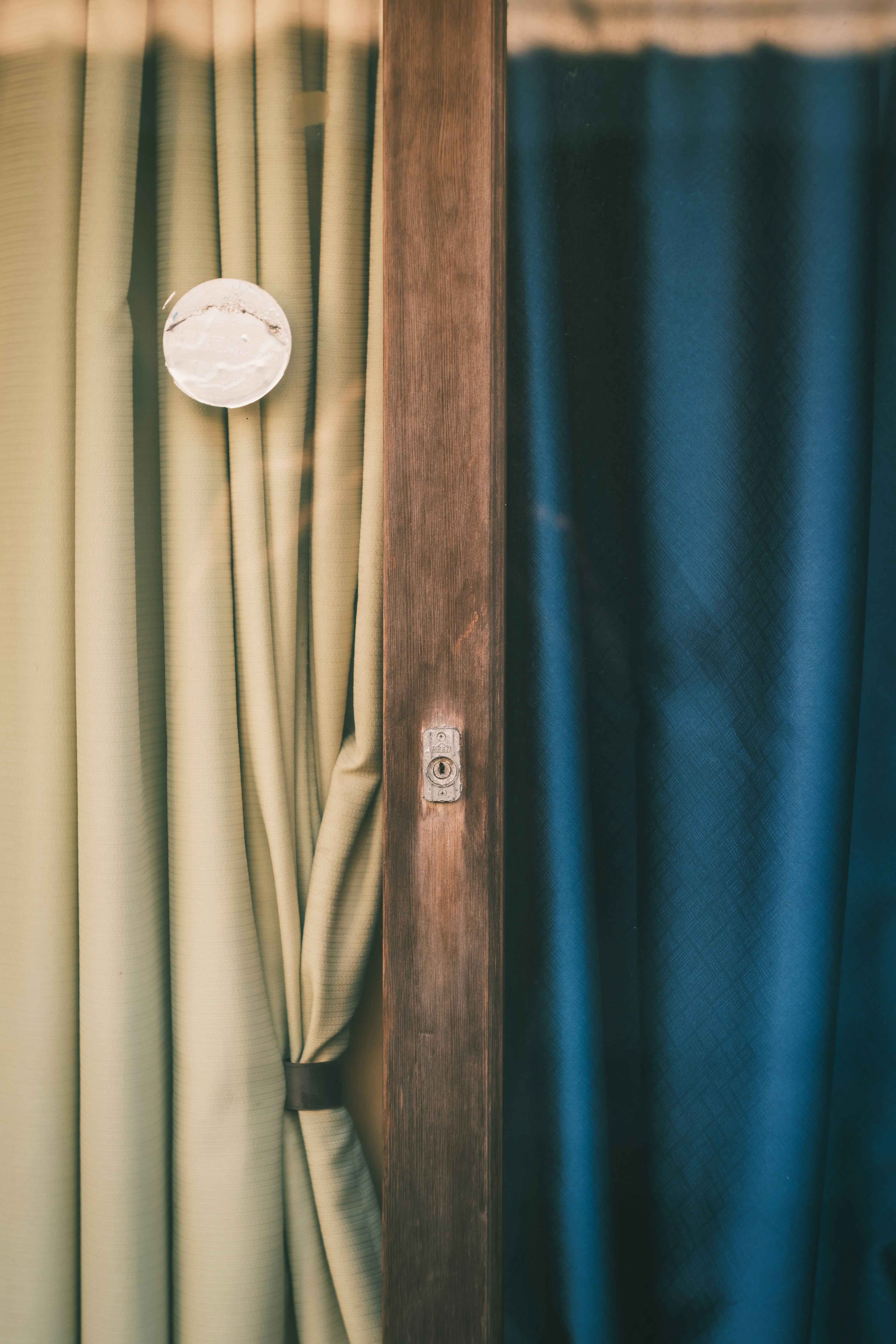 Image featuring green and blue curtains with a wooden door in the center