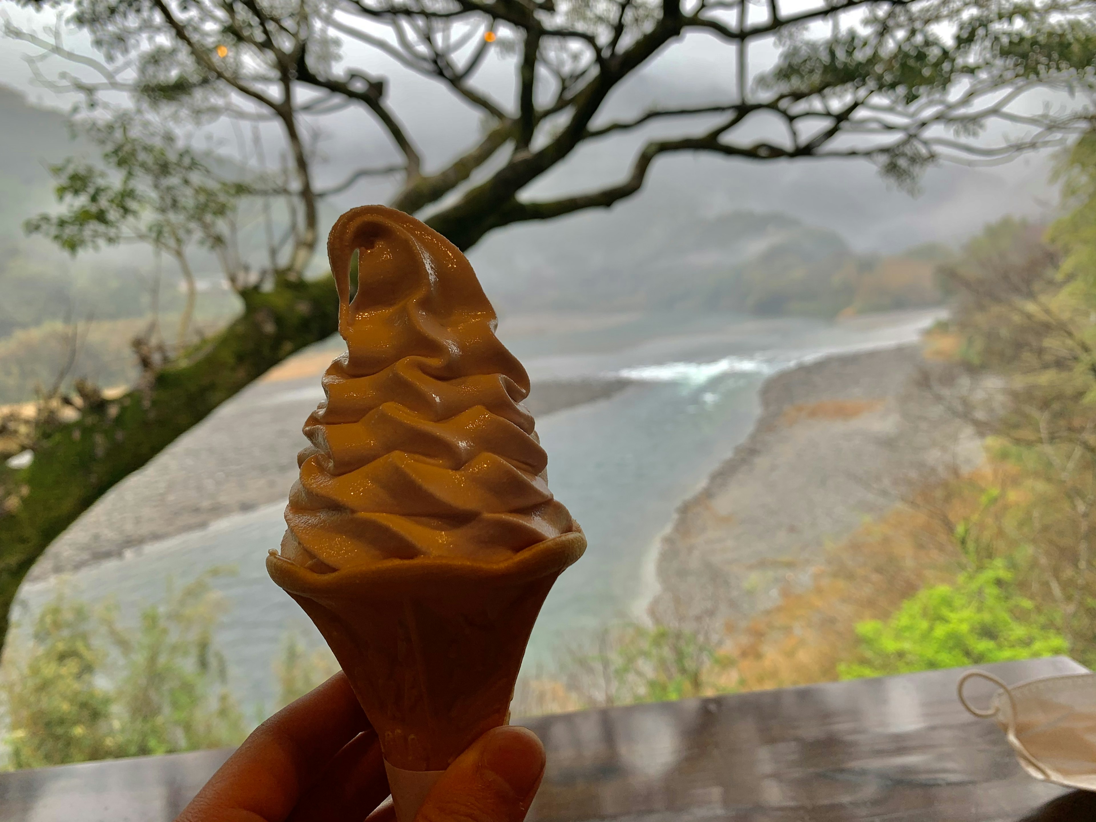 Soft serve ice cream with a misty landscape in the background