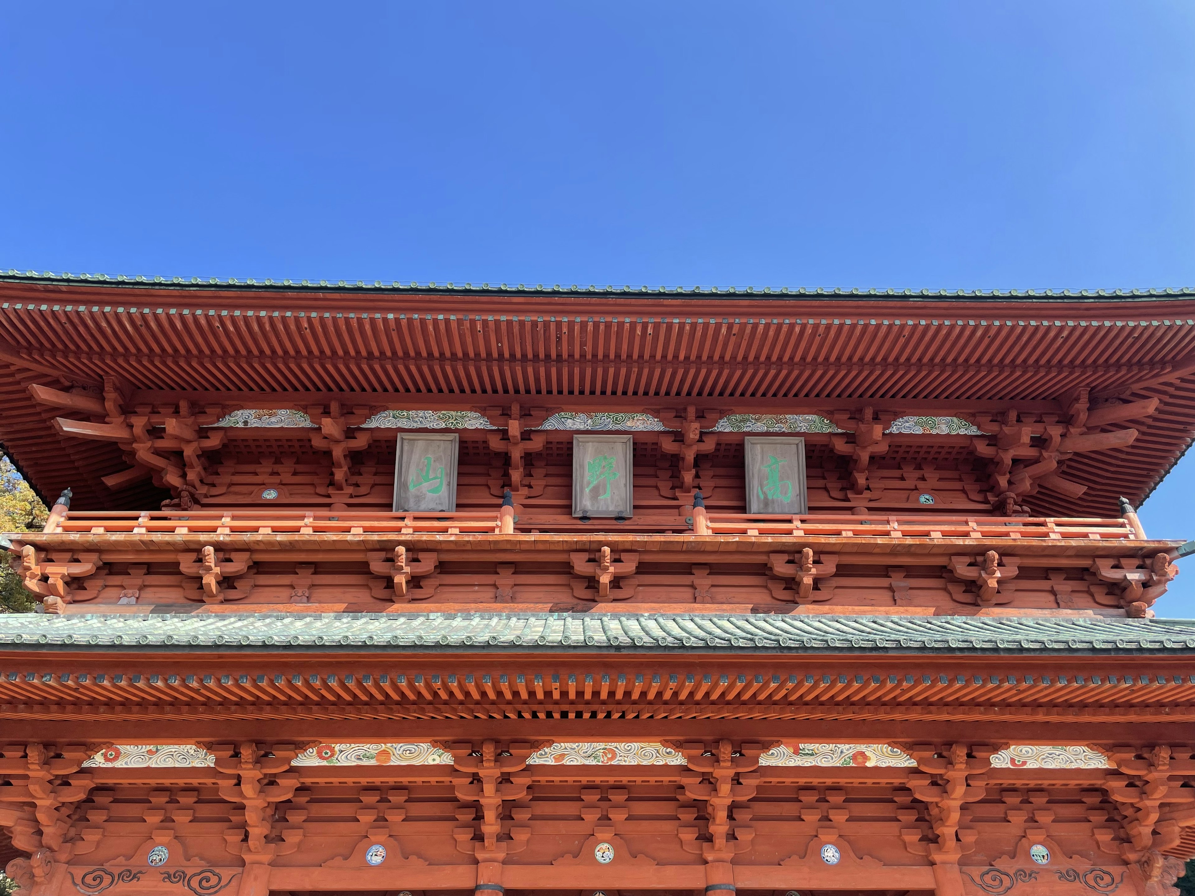 Upper part of a traditional red building against a blue sky