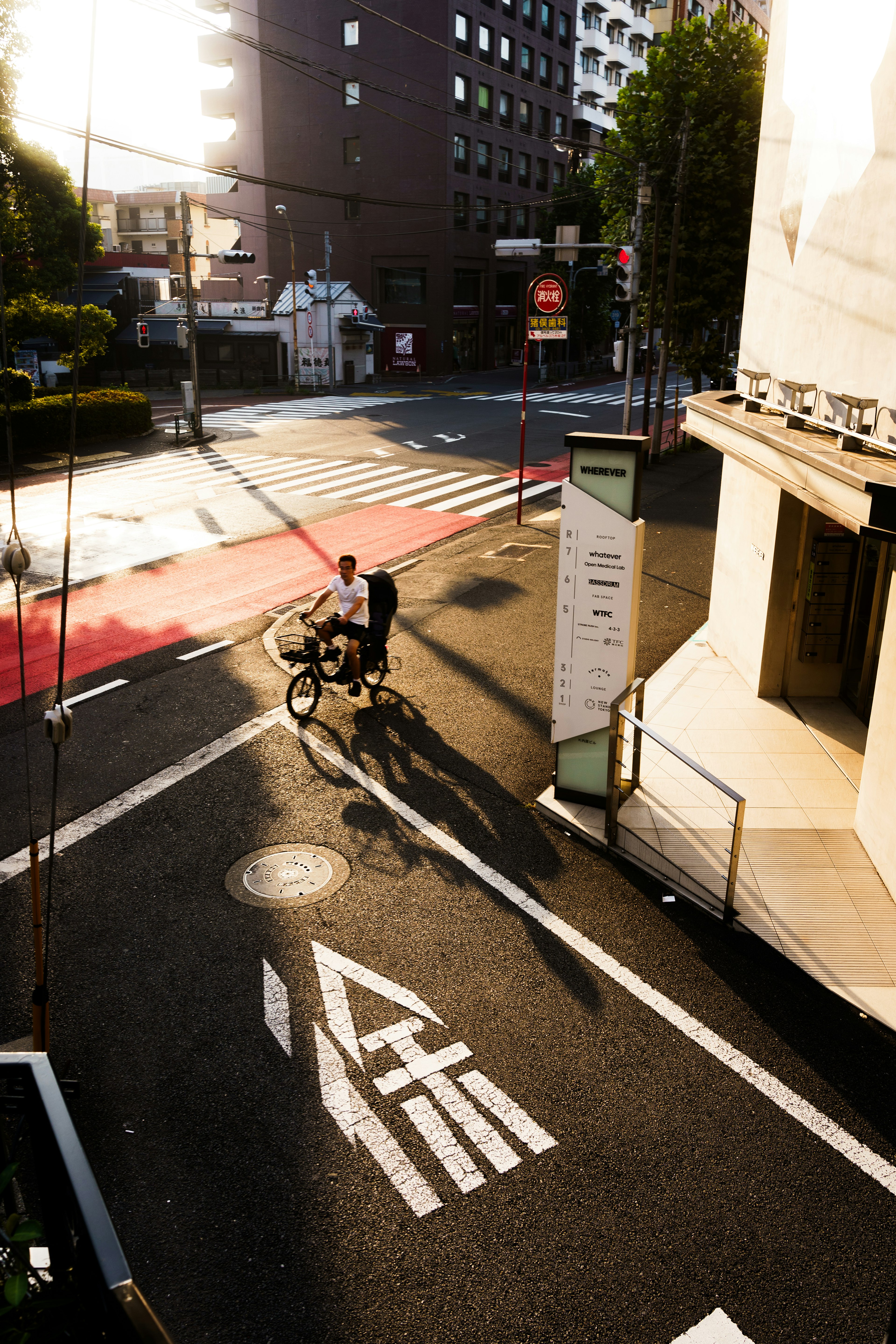 自転車に乗る男性が通りを横切る風景夕日が差し込む街角