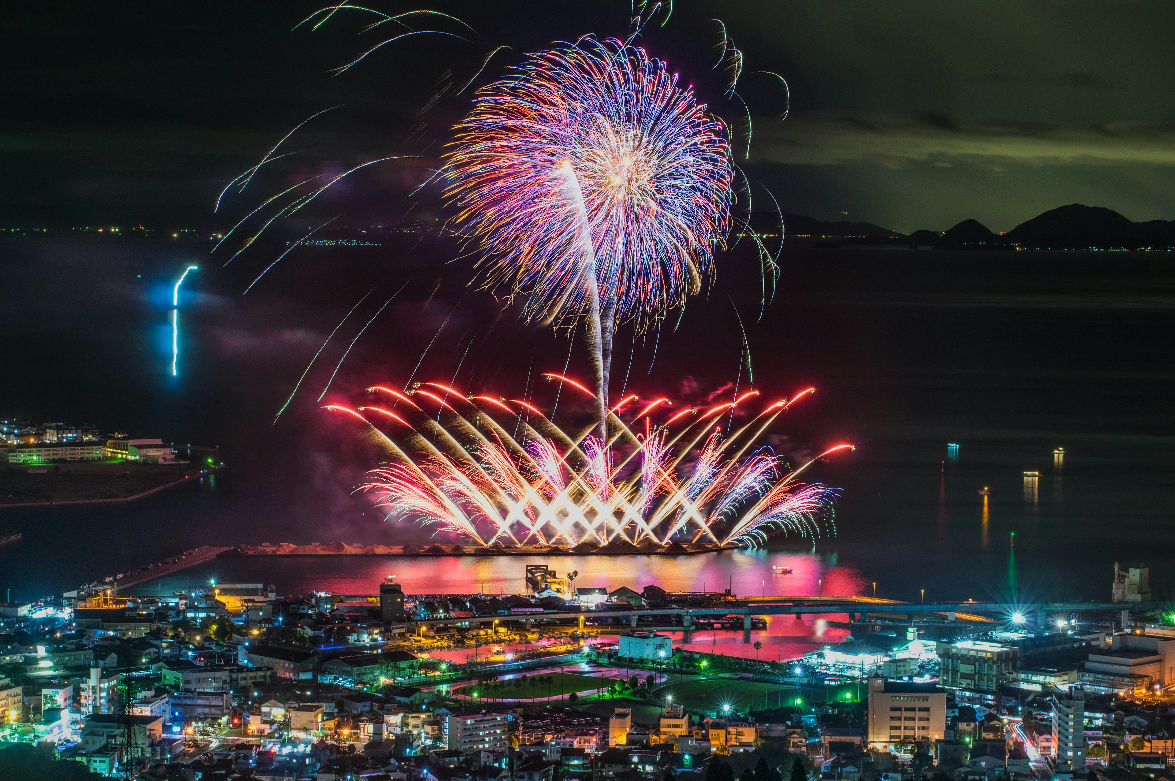 Spettacolo di fuochi d'artificio colorati che illuminano il cielo notturno su una città vivace