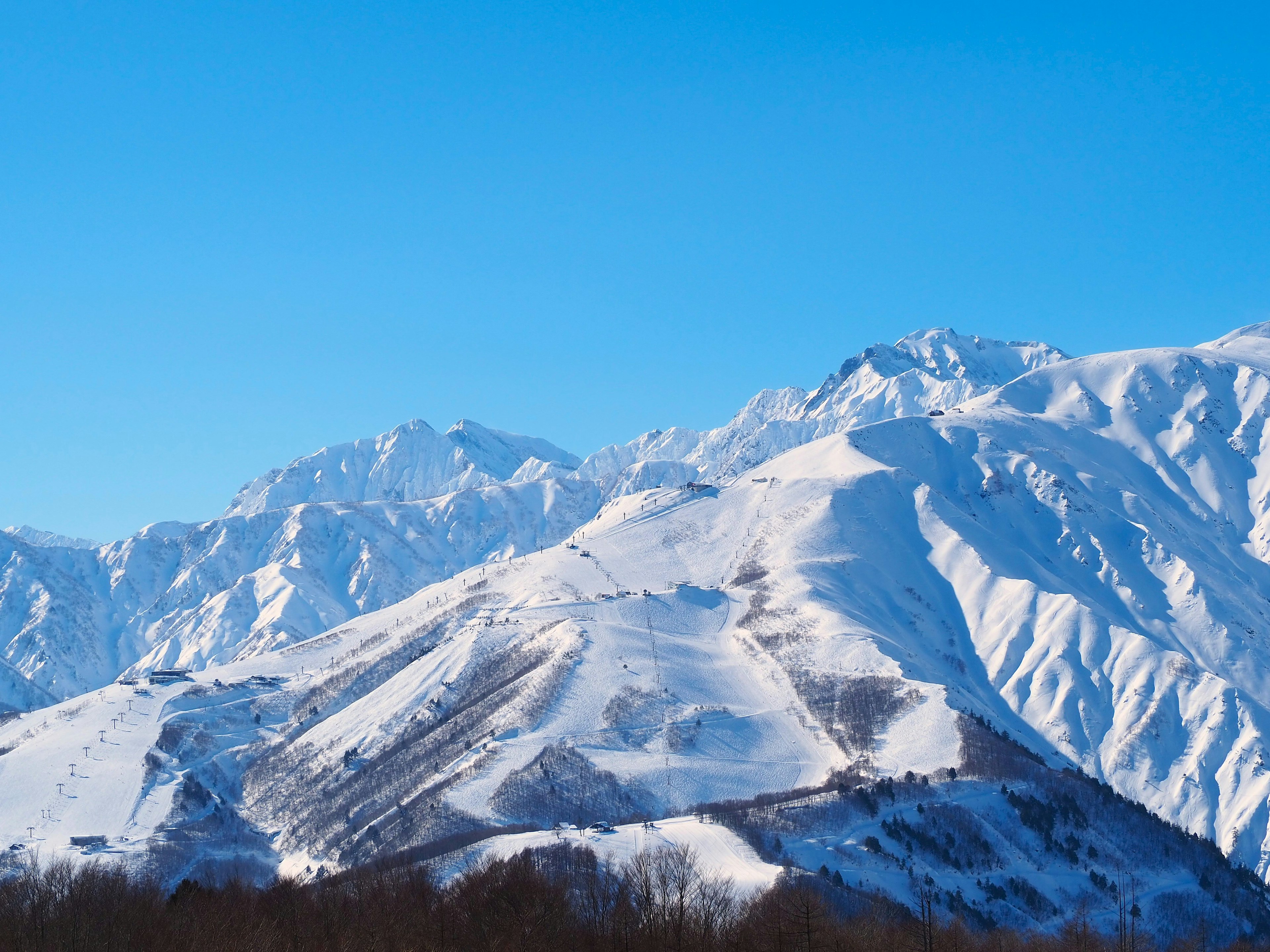 Montañas cubiertas de nieve bajo un cielo azul claro