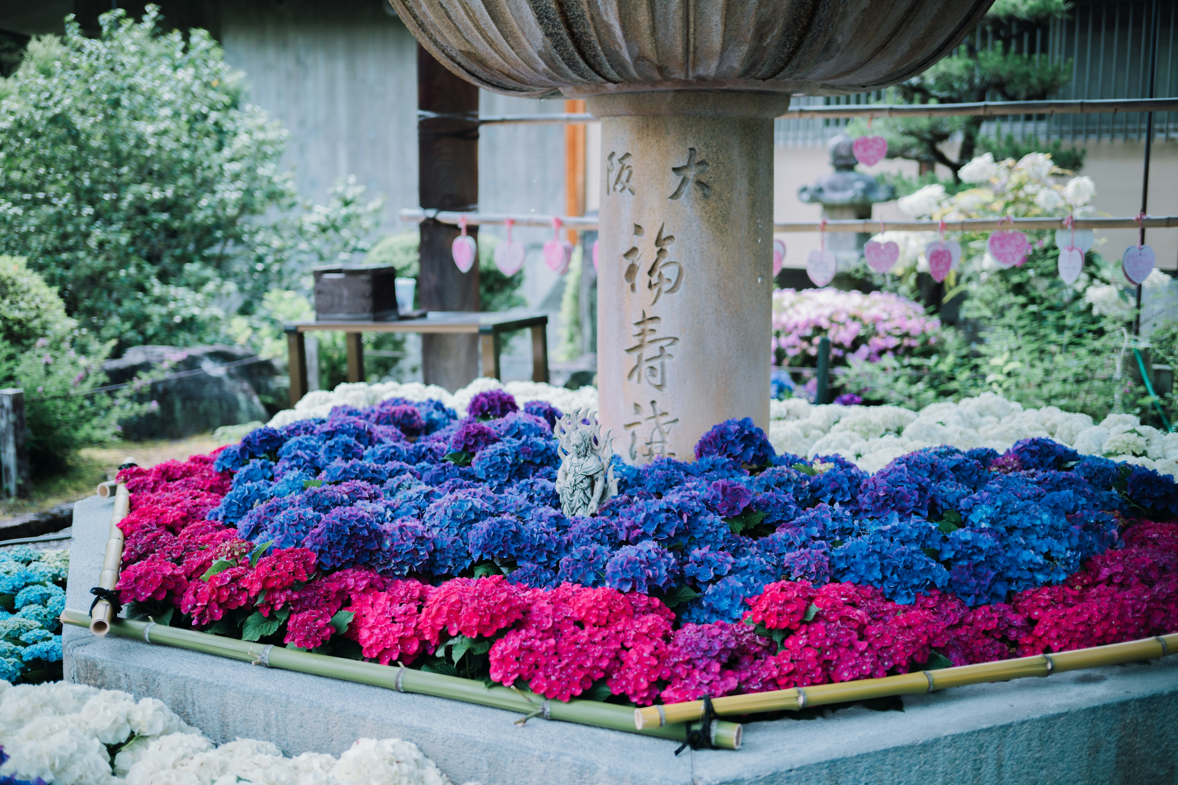 A stone lantern surrounded by vibrant flowers in a garden