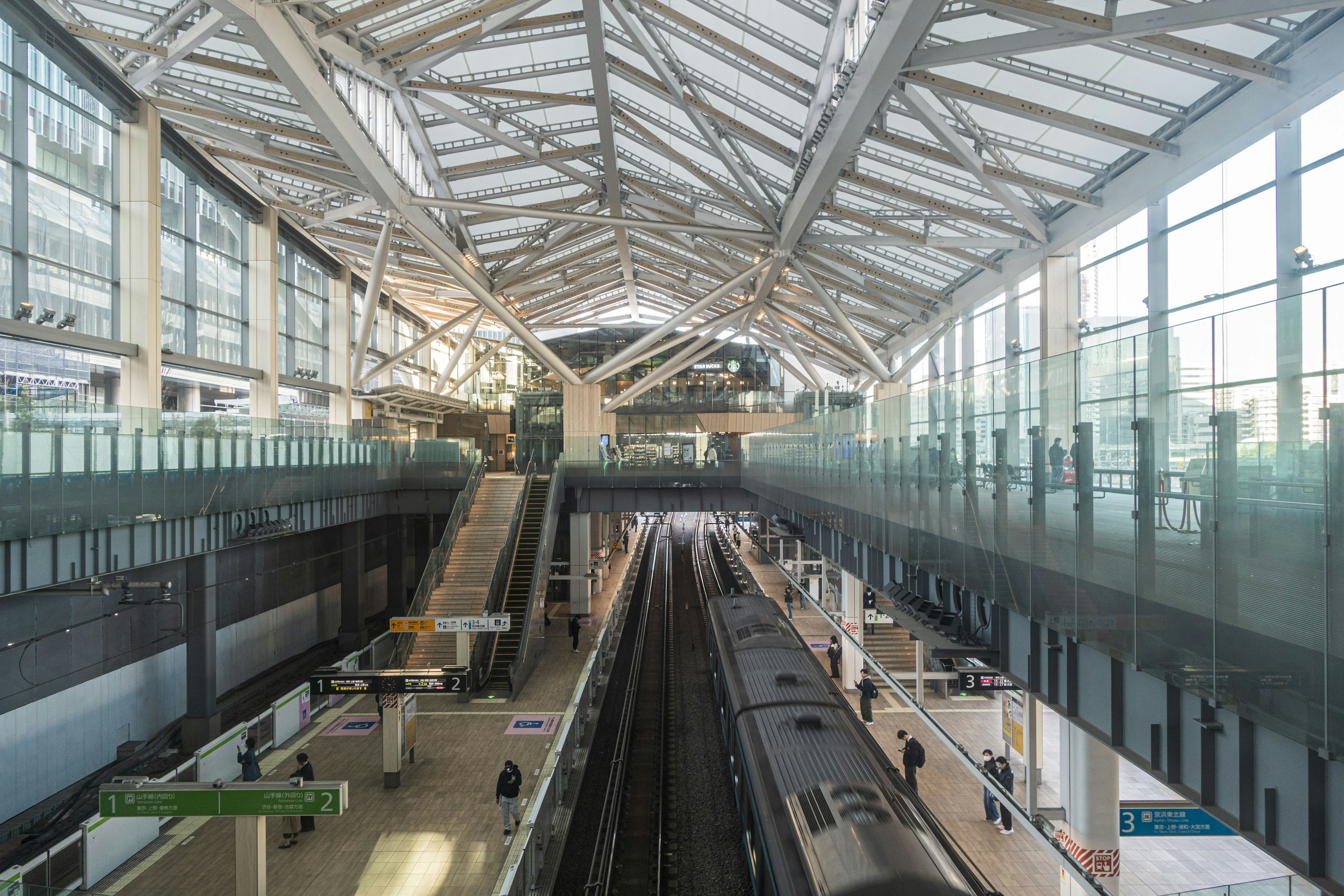 ภายในสถานีรถไฟสมัยใหม่ที่มีชานชาลาและเพดานกระจก