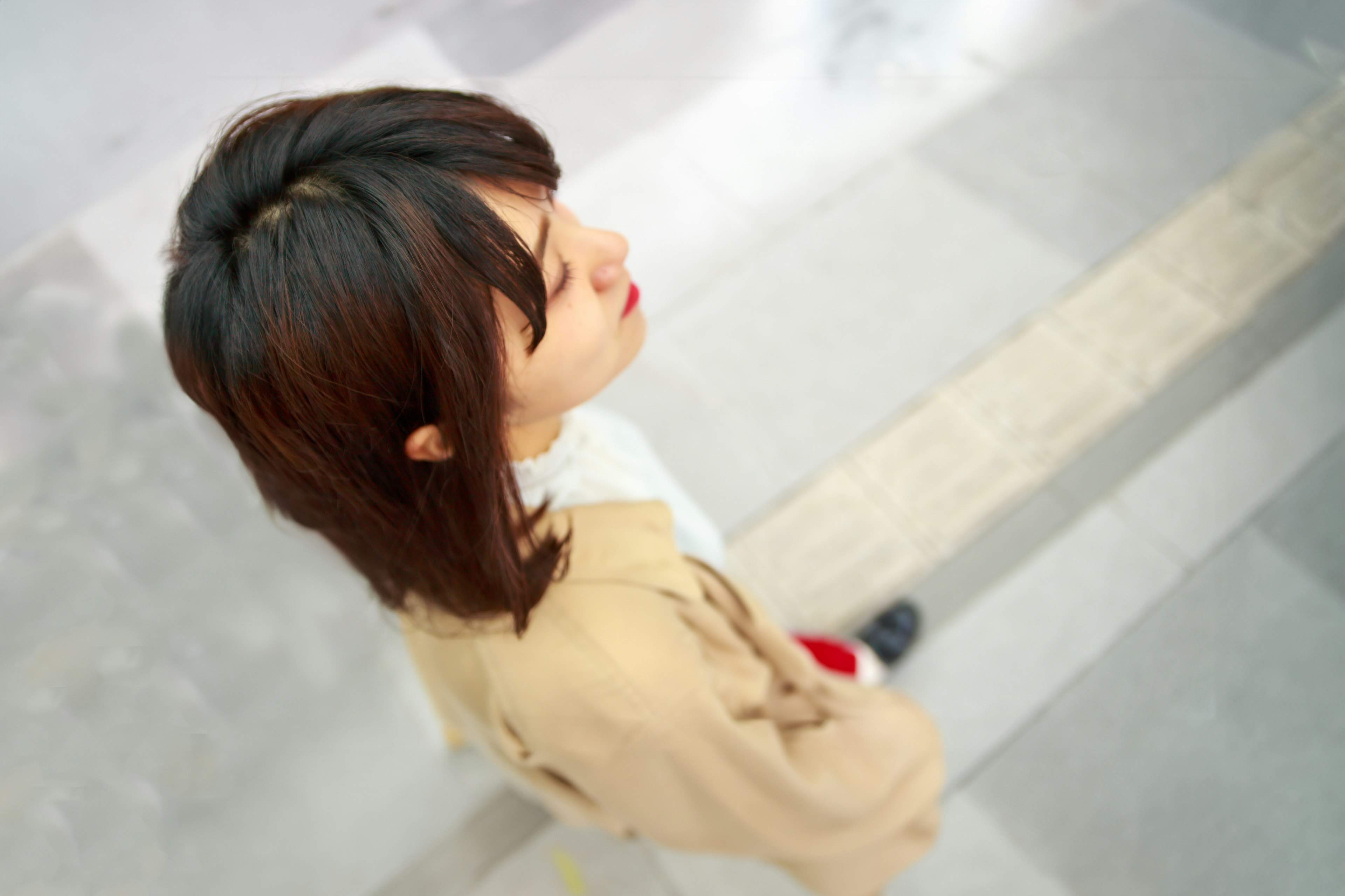 A woman seen from above wearing a brown outfit with a modern background