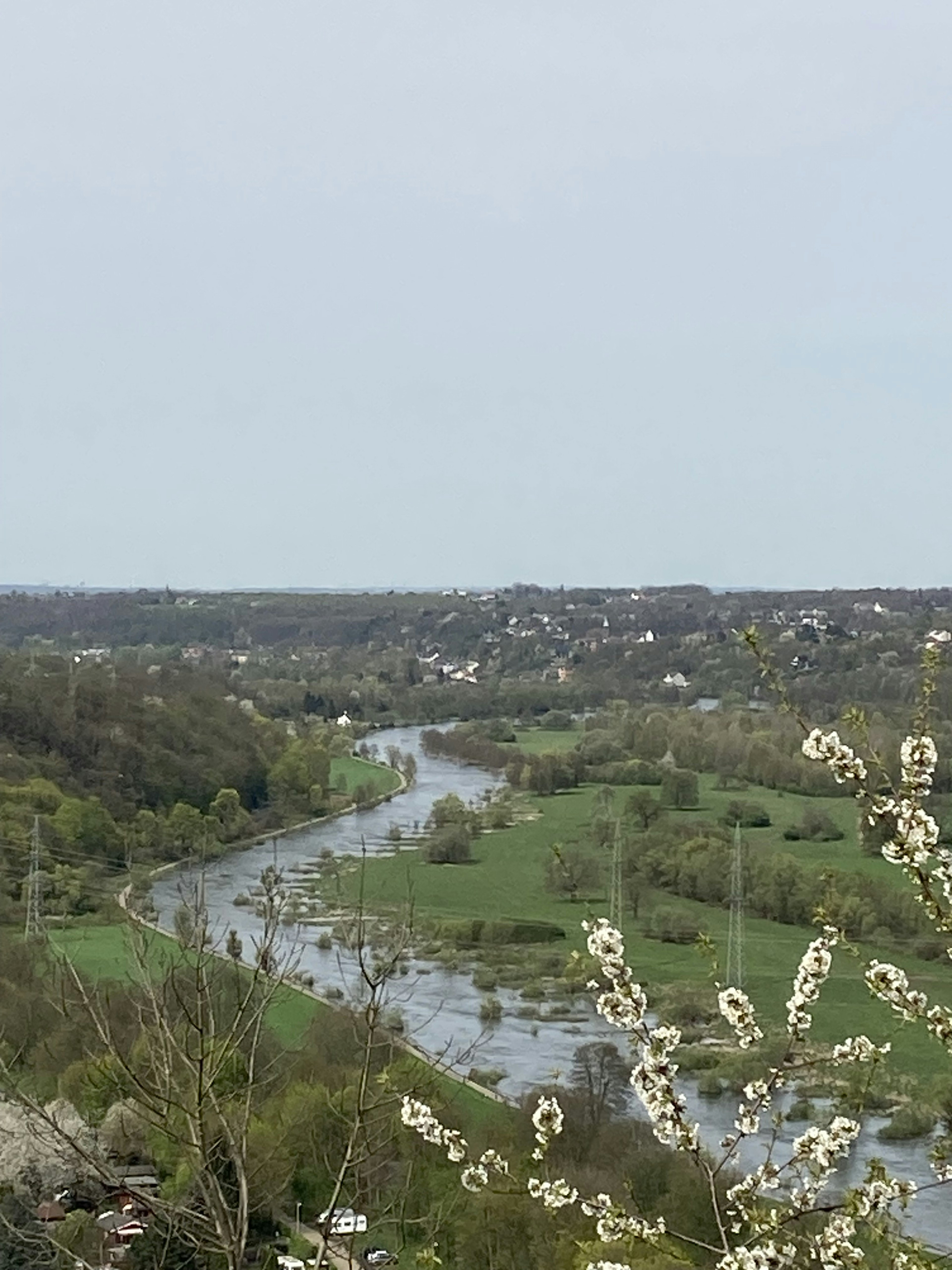 Vista desde una colina con un río que serpentea a través de un paisaje verde