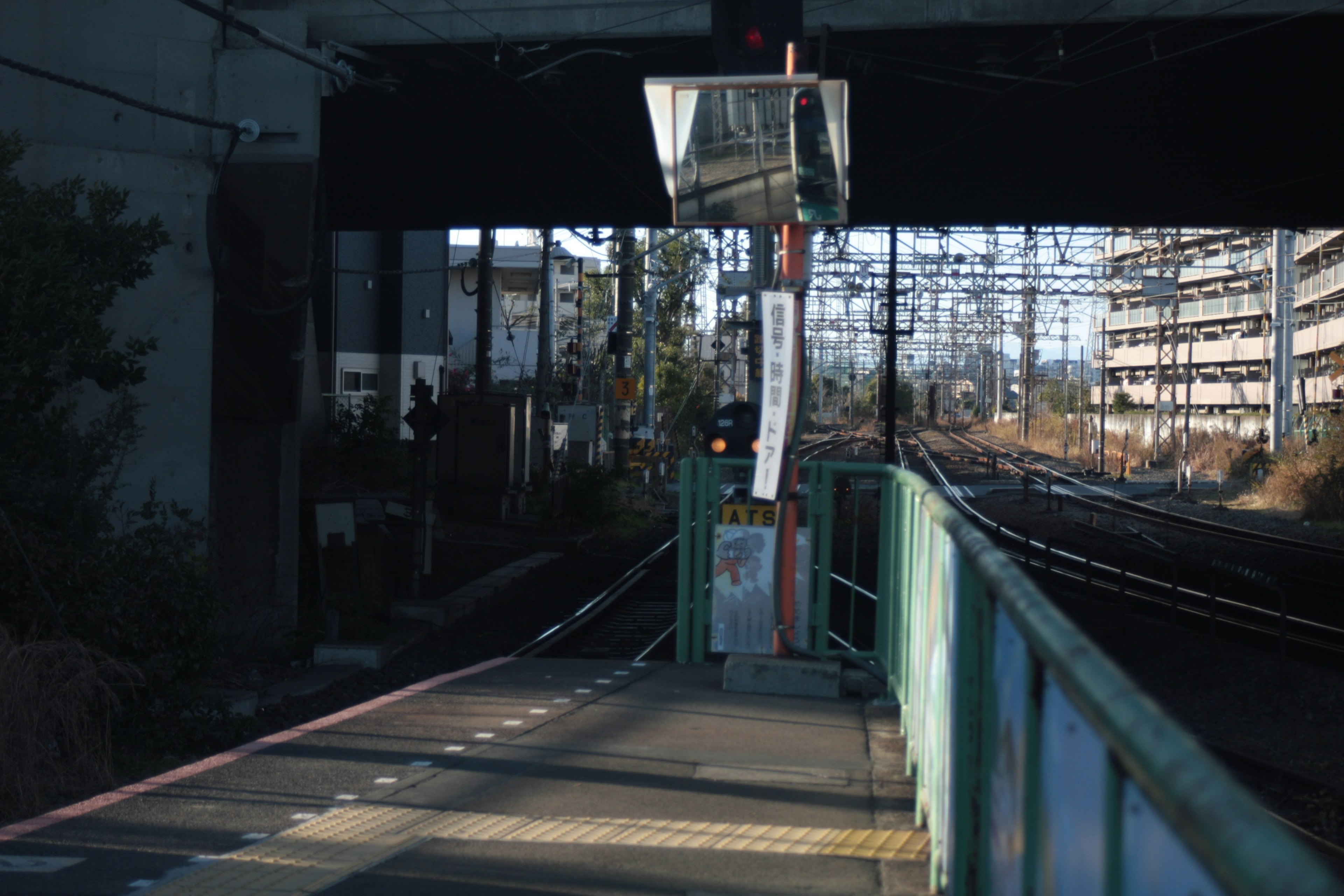 Plataforma de tren tranquila con vías y estructuras circundantes