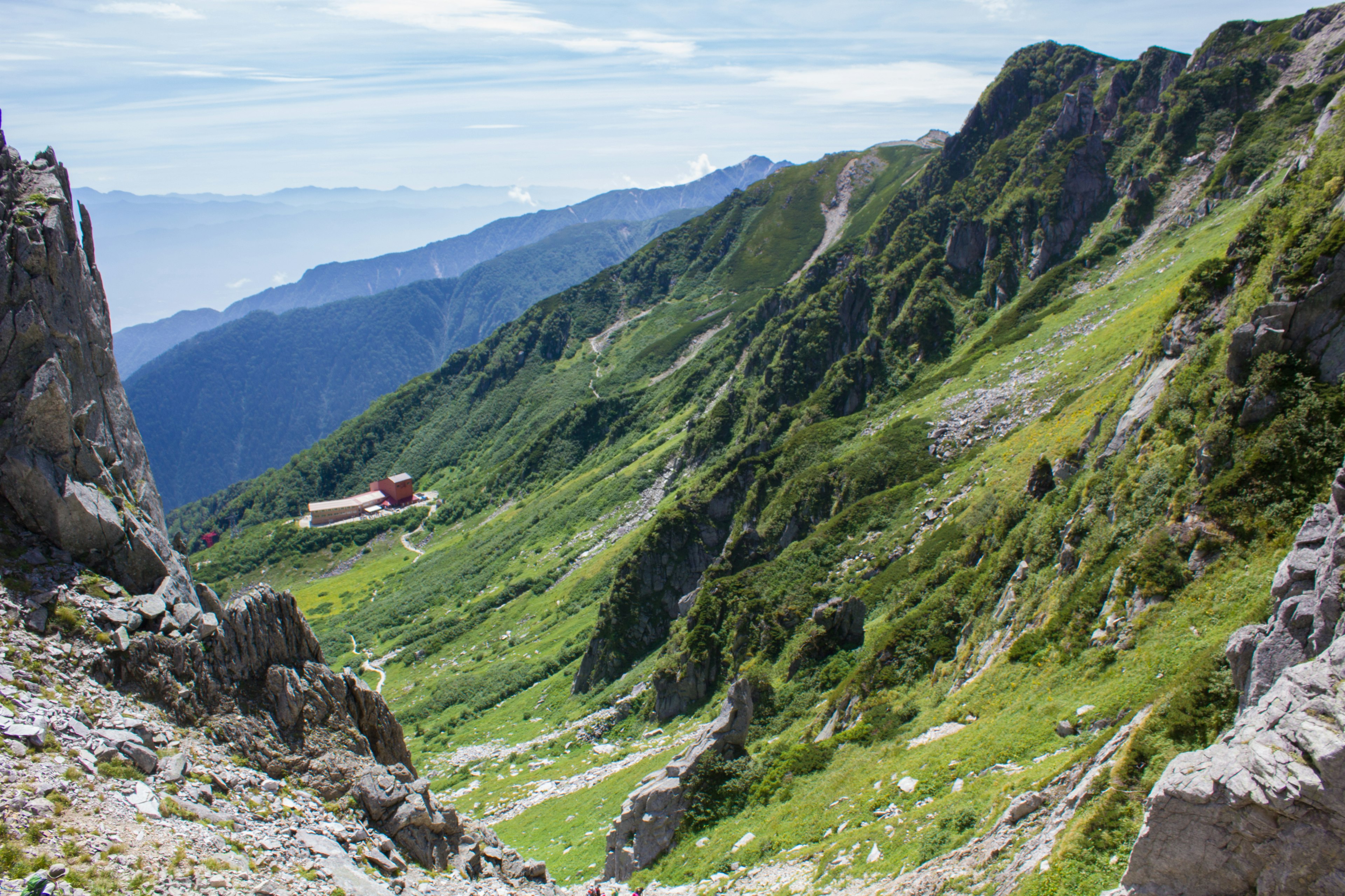 Una bella valle con una capanna rossa e prati verdi