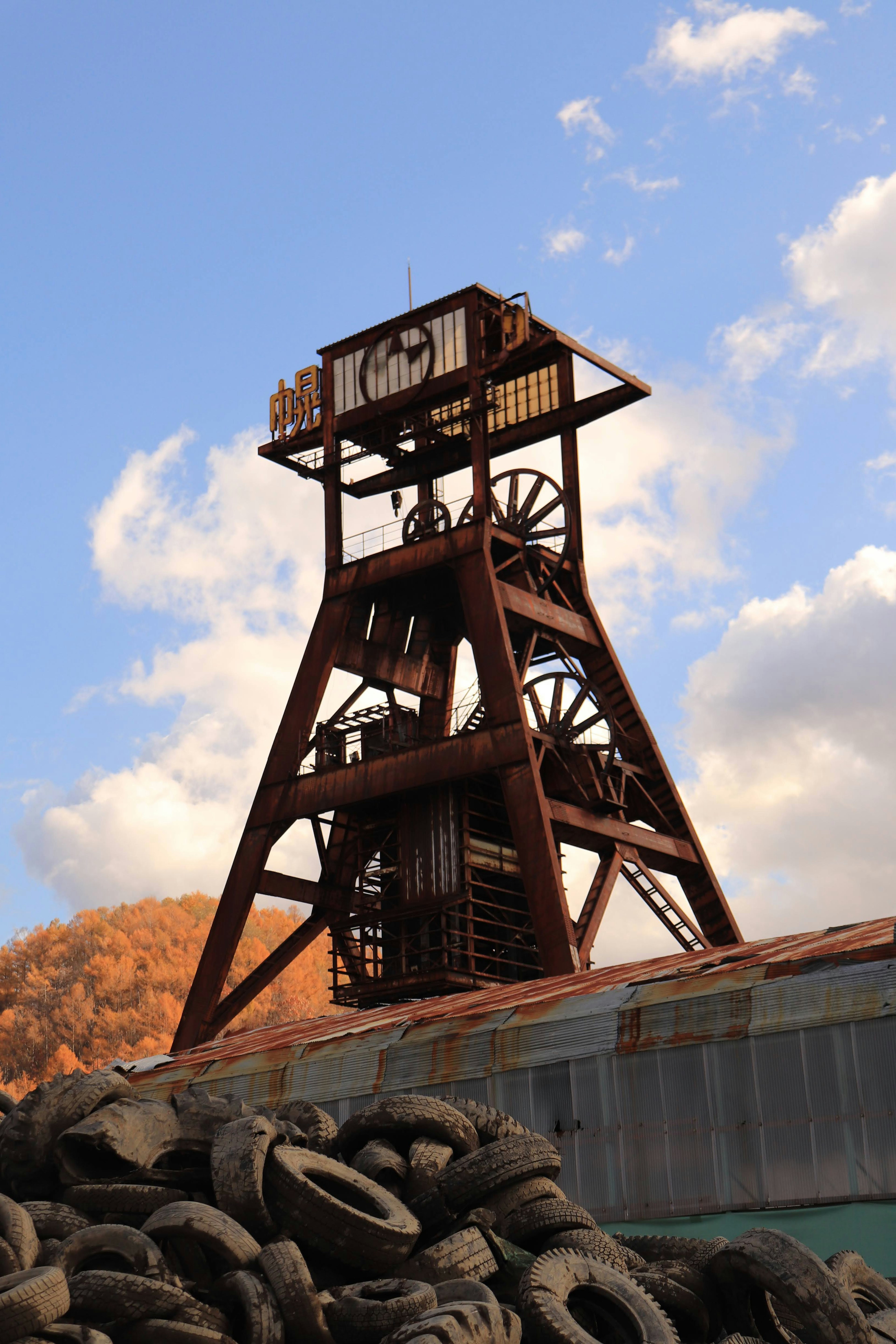 Tour de mine rouge avec un tas de vieux pneus au premier plan