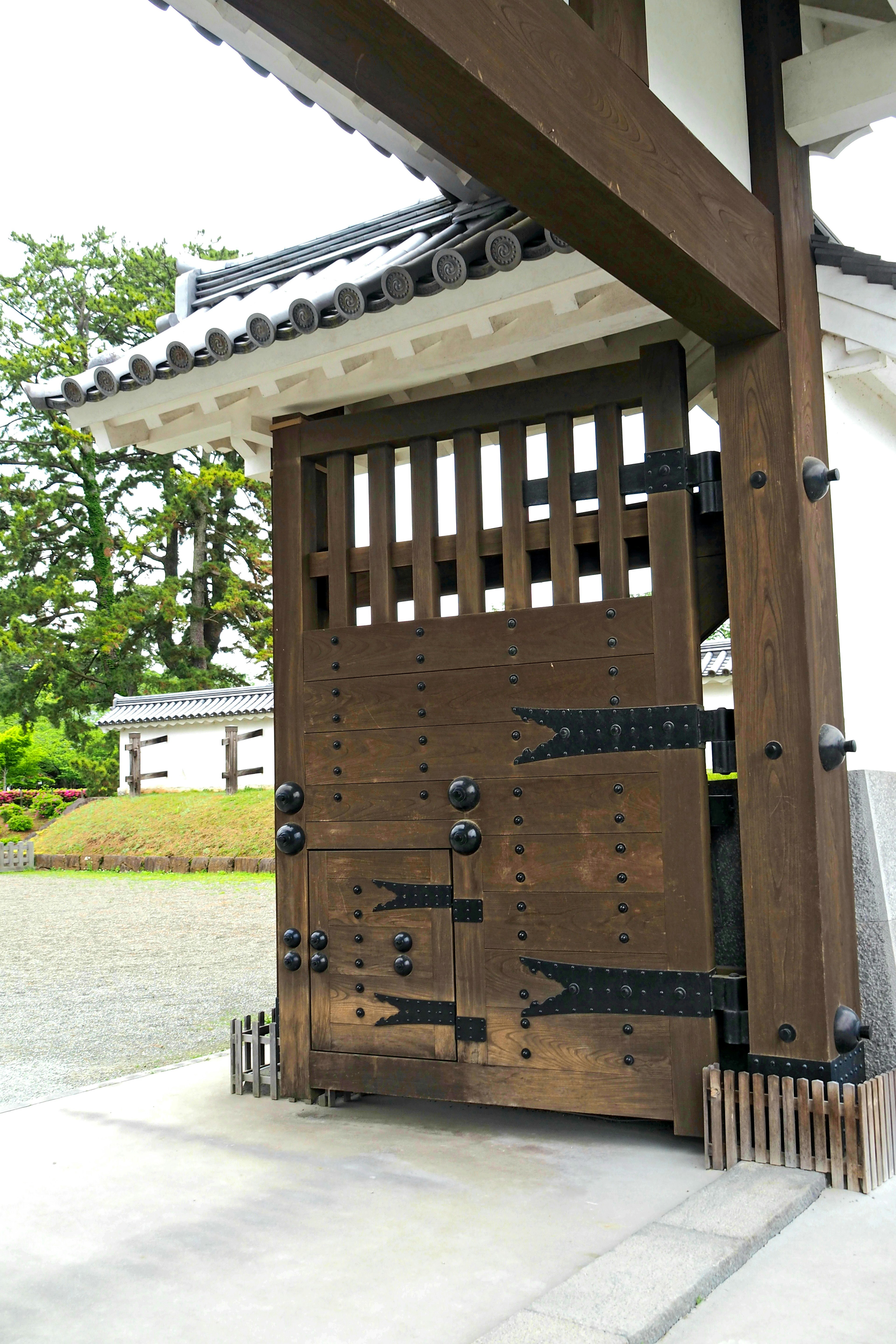 Detailed image of a traditional Japanese wooden gate featuring intricate hardware and classic design