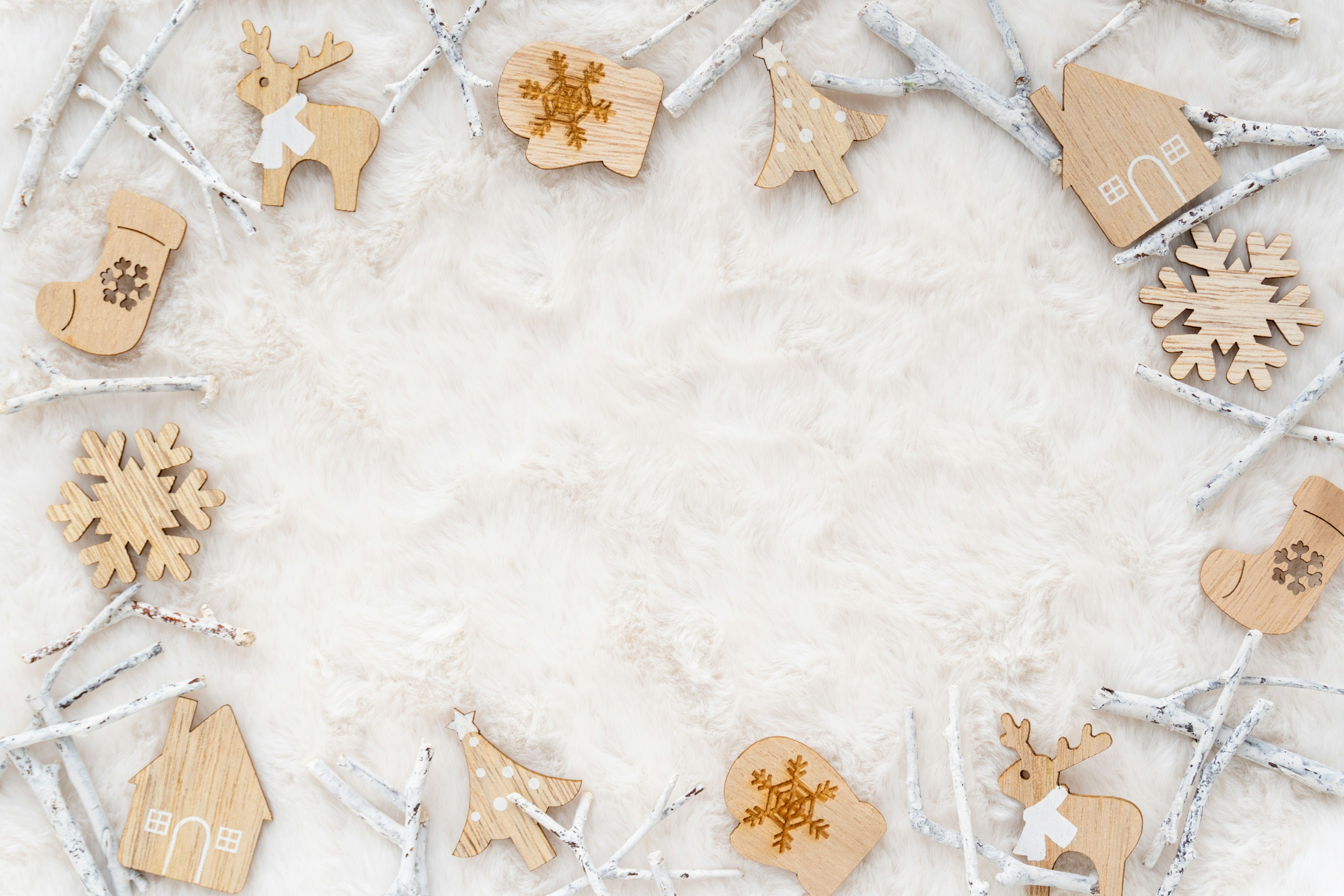 Circular arrangement of wooden Christmas ornaments on a snowy background