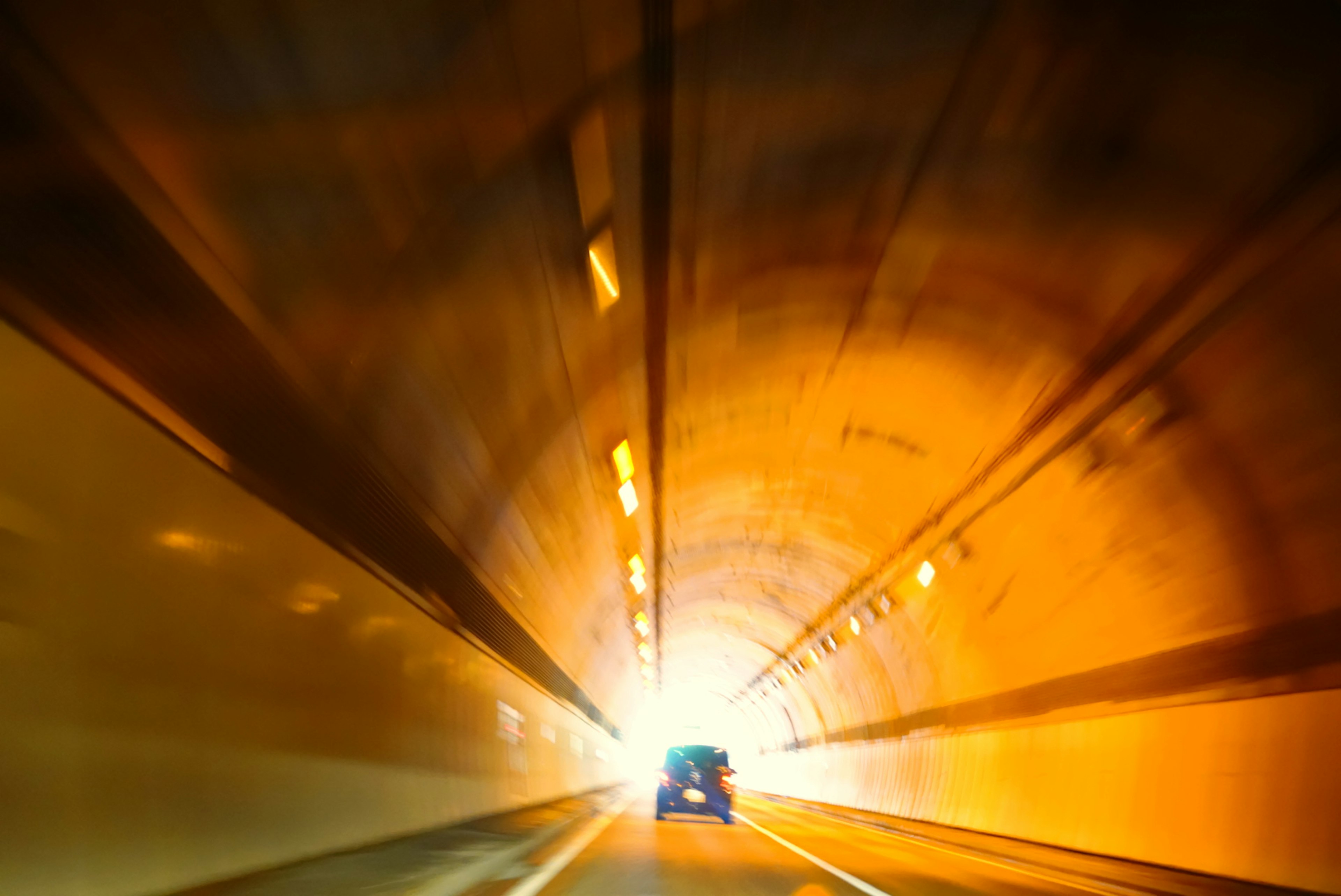 Auto fährt durch einen Tunnel mit hellem Licht am Ende