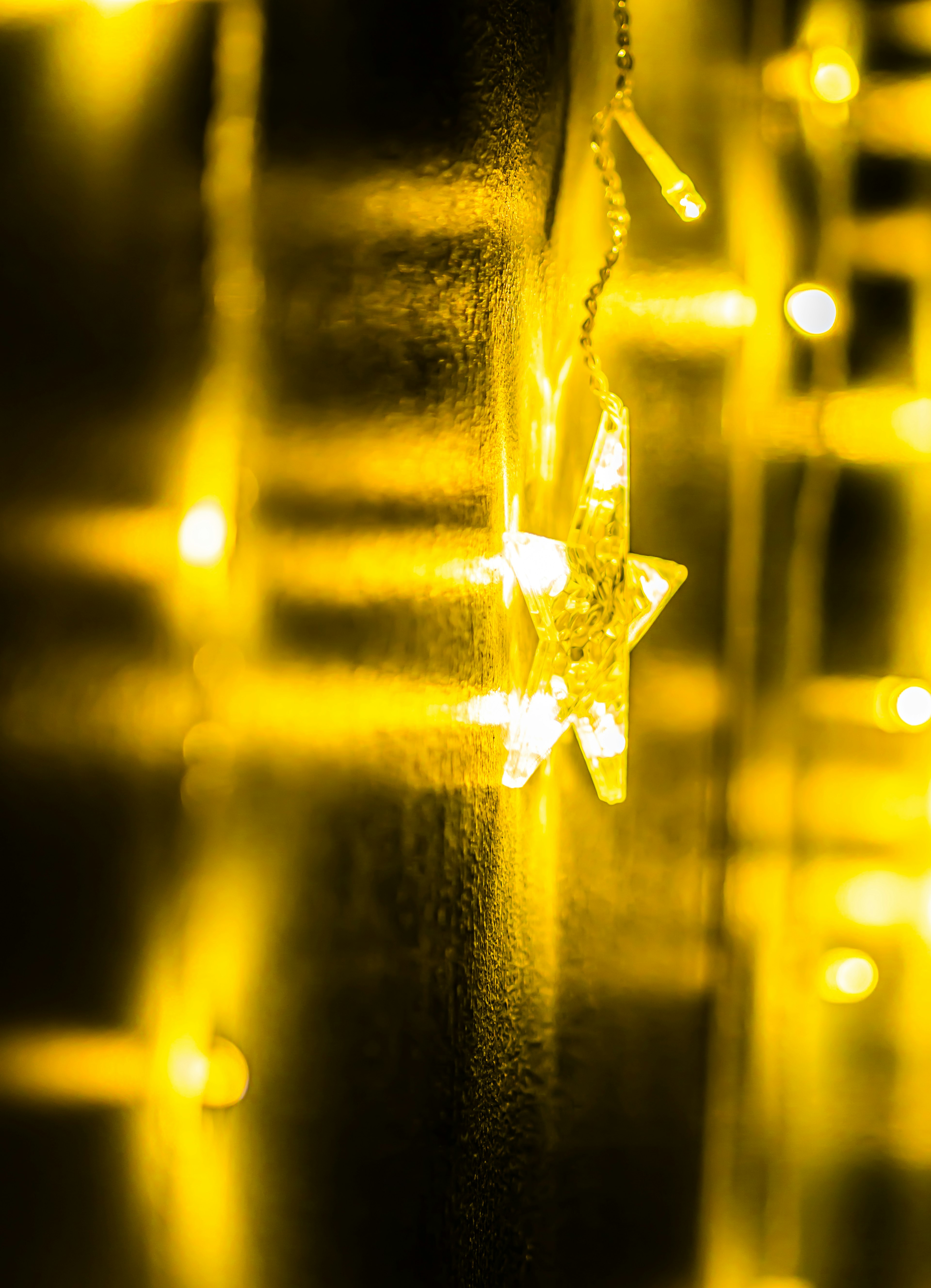 Star-shaped decoration emitting yellow light on a wall