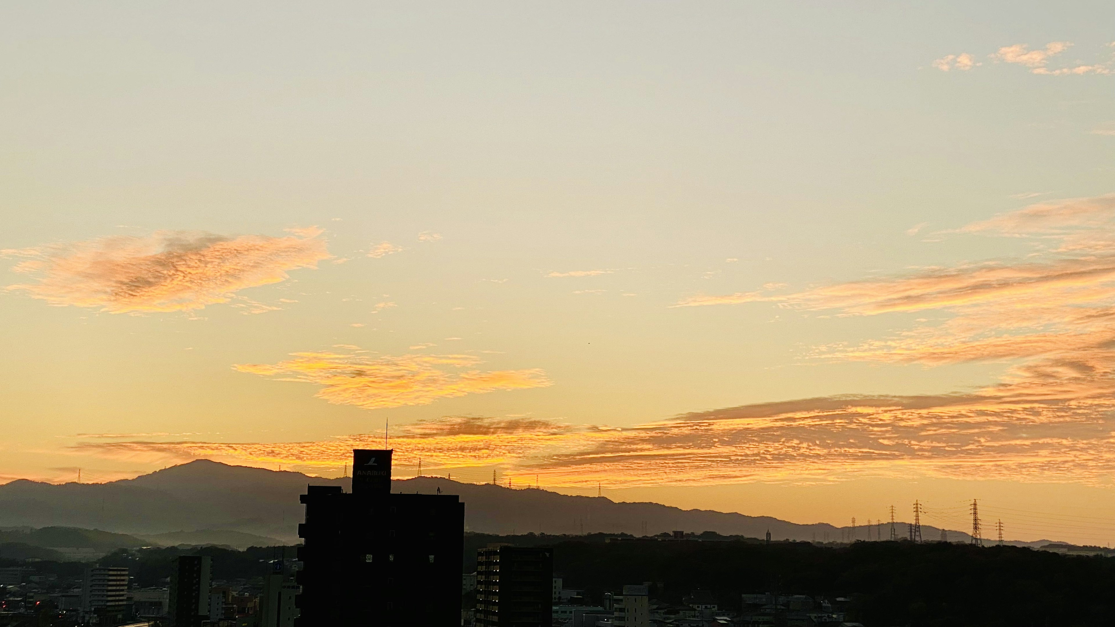 城市天際線與日落天空和山脈輪廓