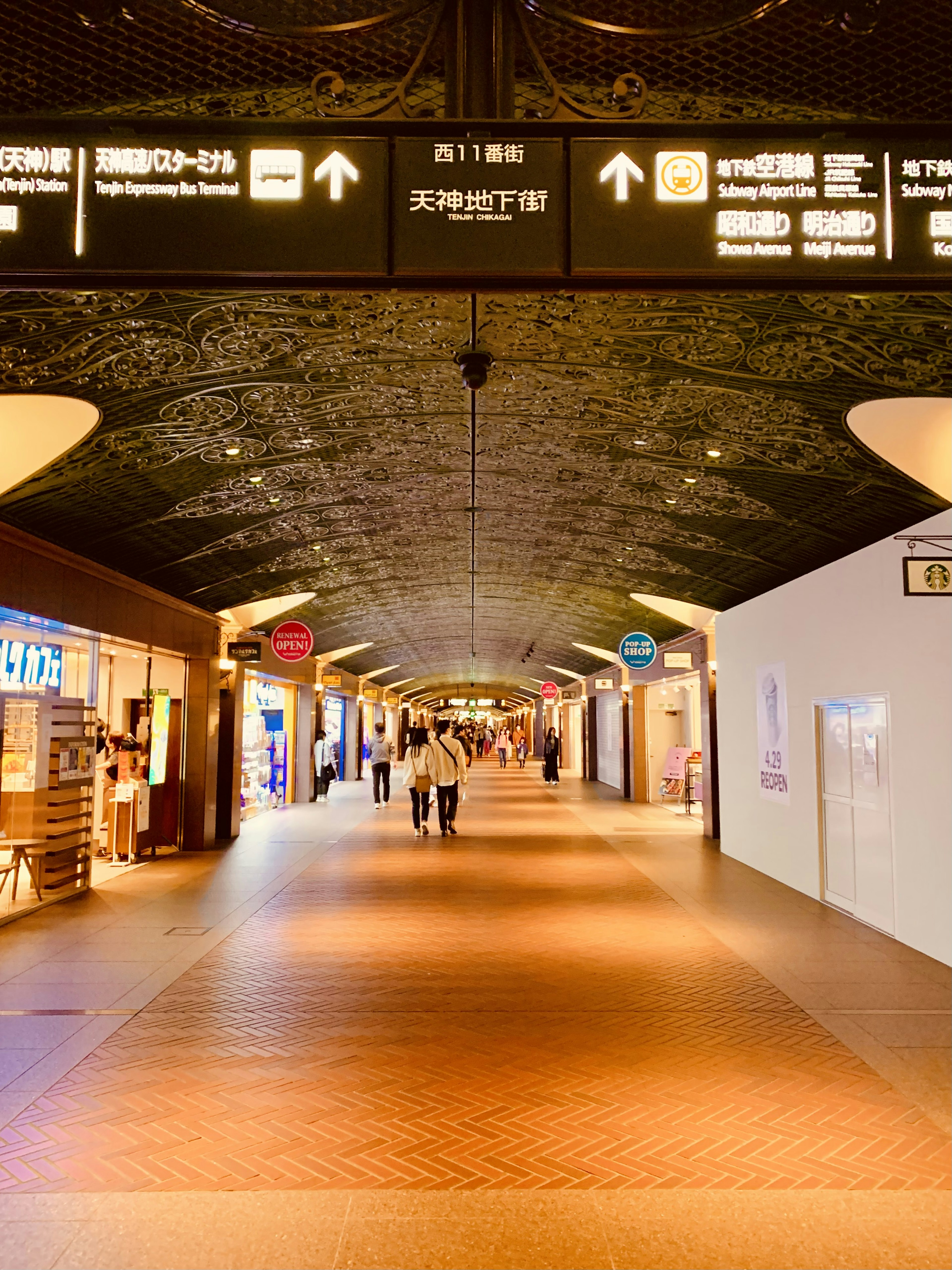 Spacious airport corridor with people walking Bright lighting and visible signs