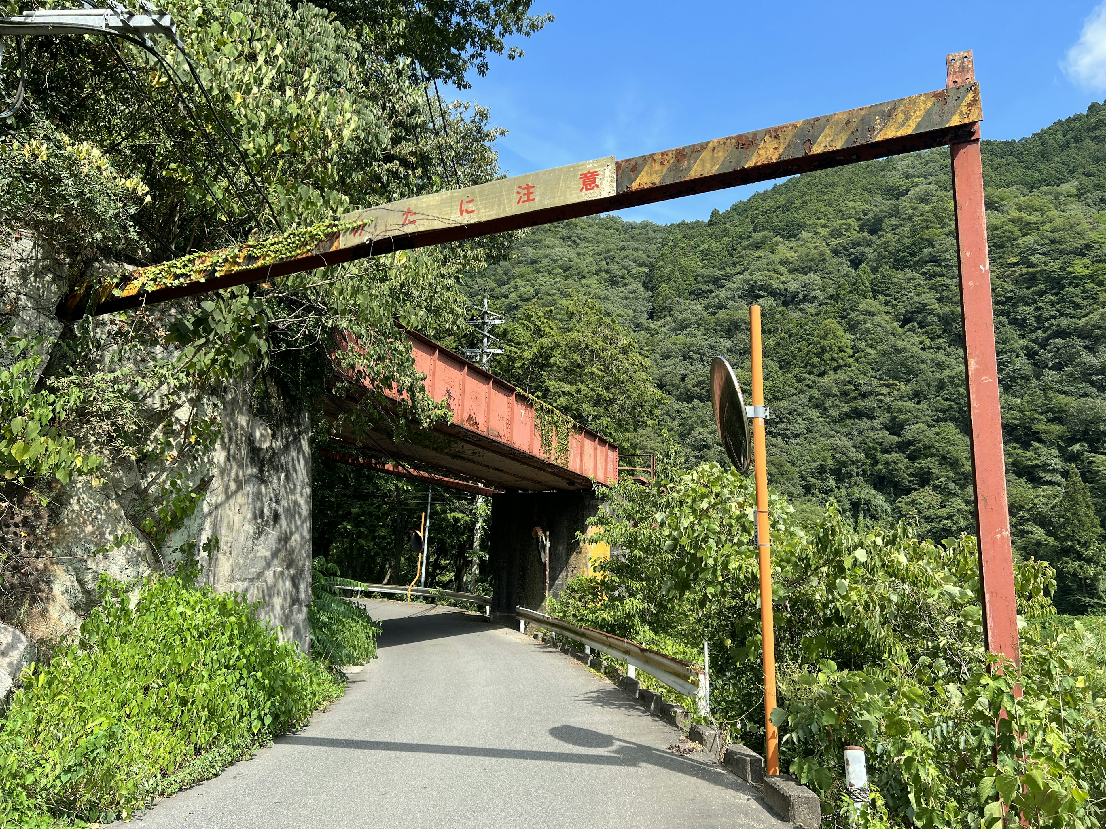 Rusty metal arch over a mountain road