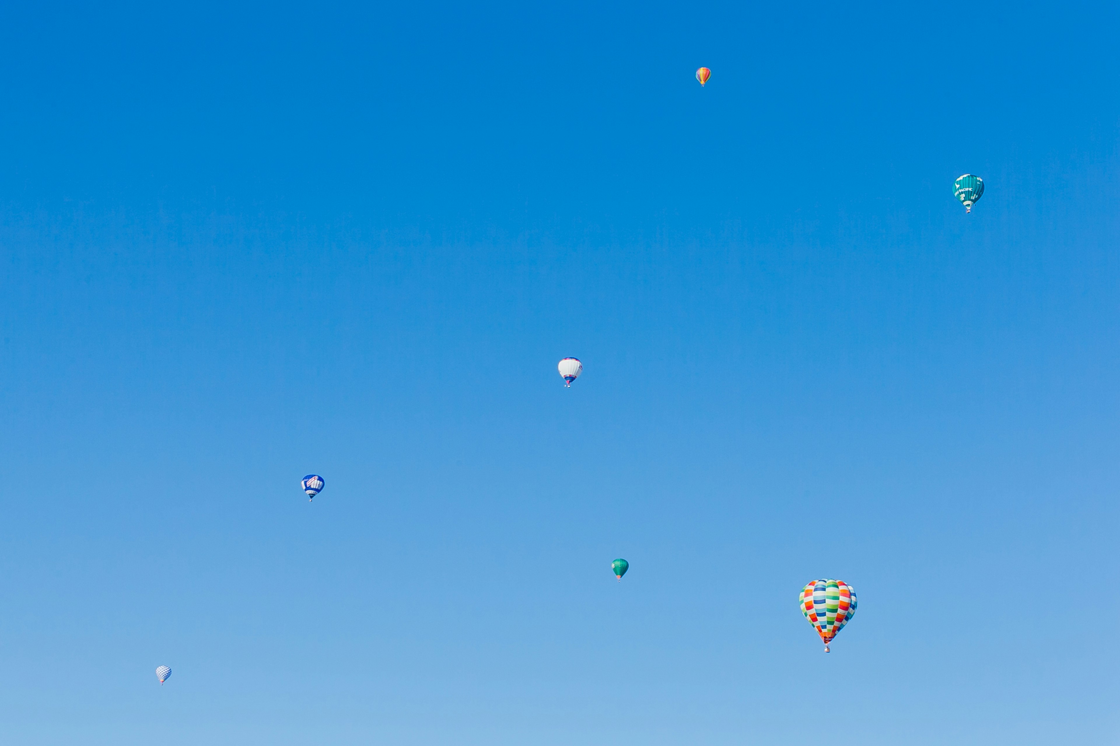 Colorati palloni aerostatici che fluttuano in un cielo blu chiaro