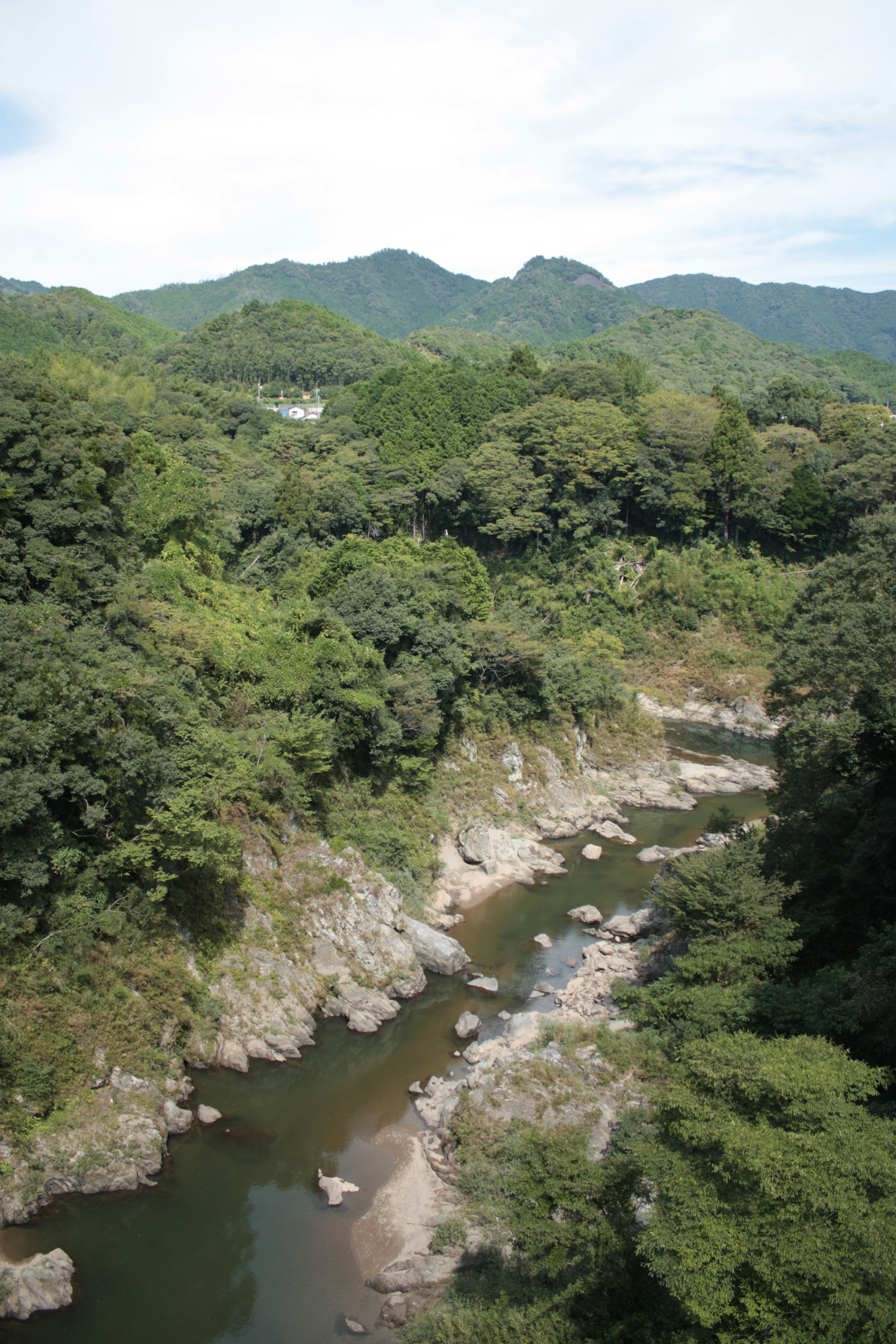 Pemandangan sungai tenang dengan pegunungan hijau