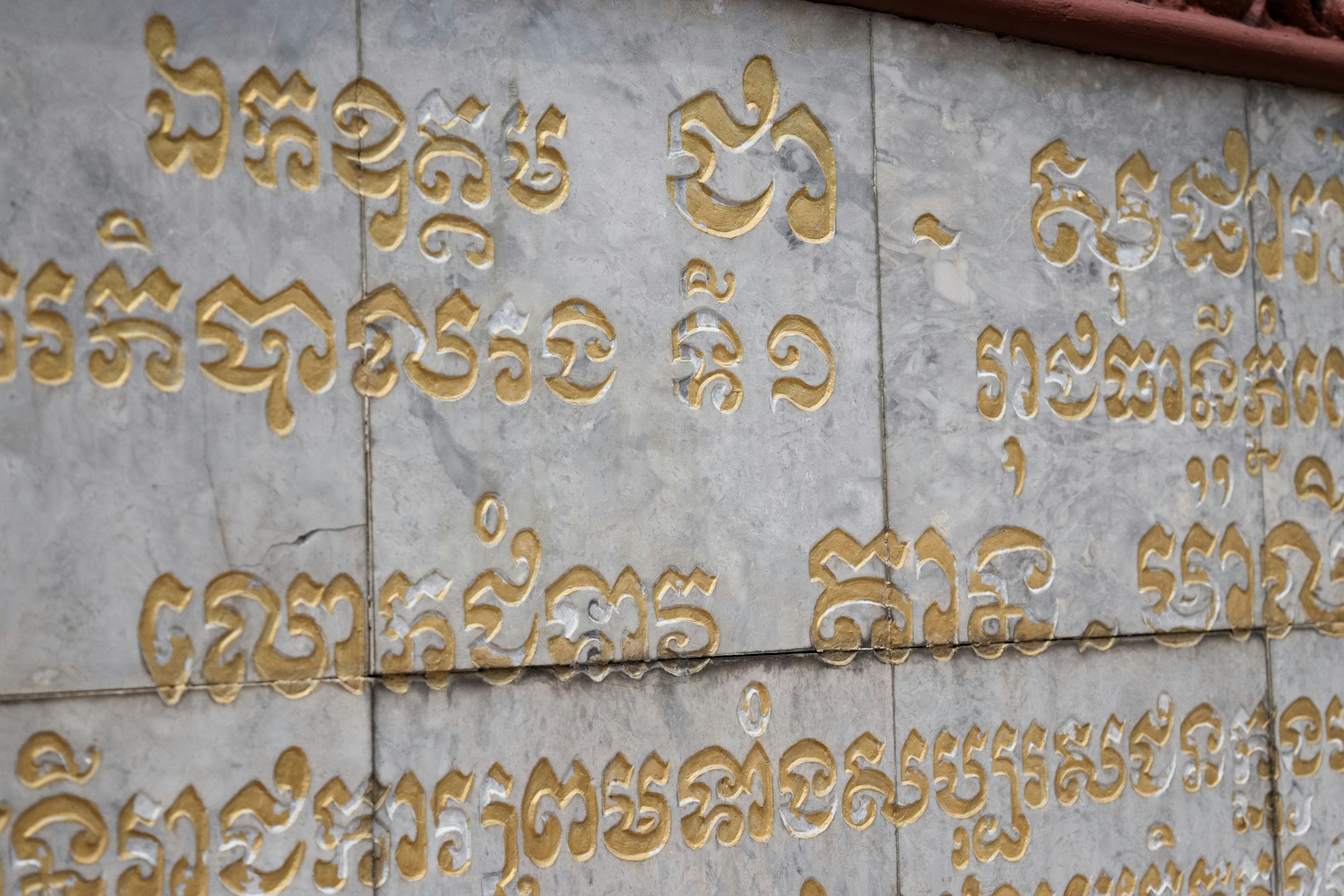 Section d'un mur en pierre avec du texte doré gravé