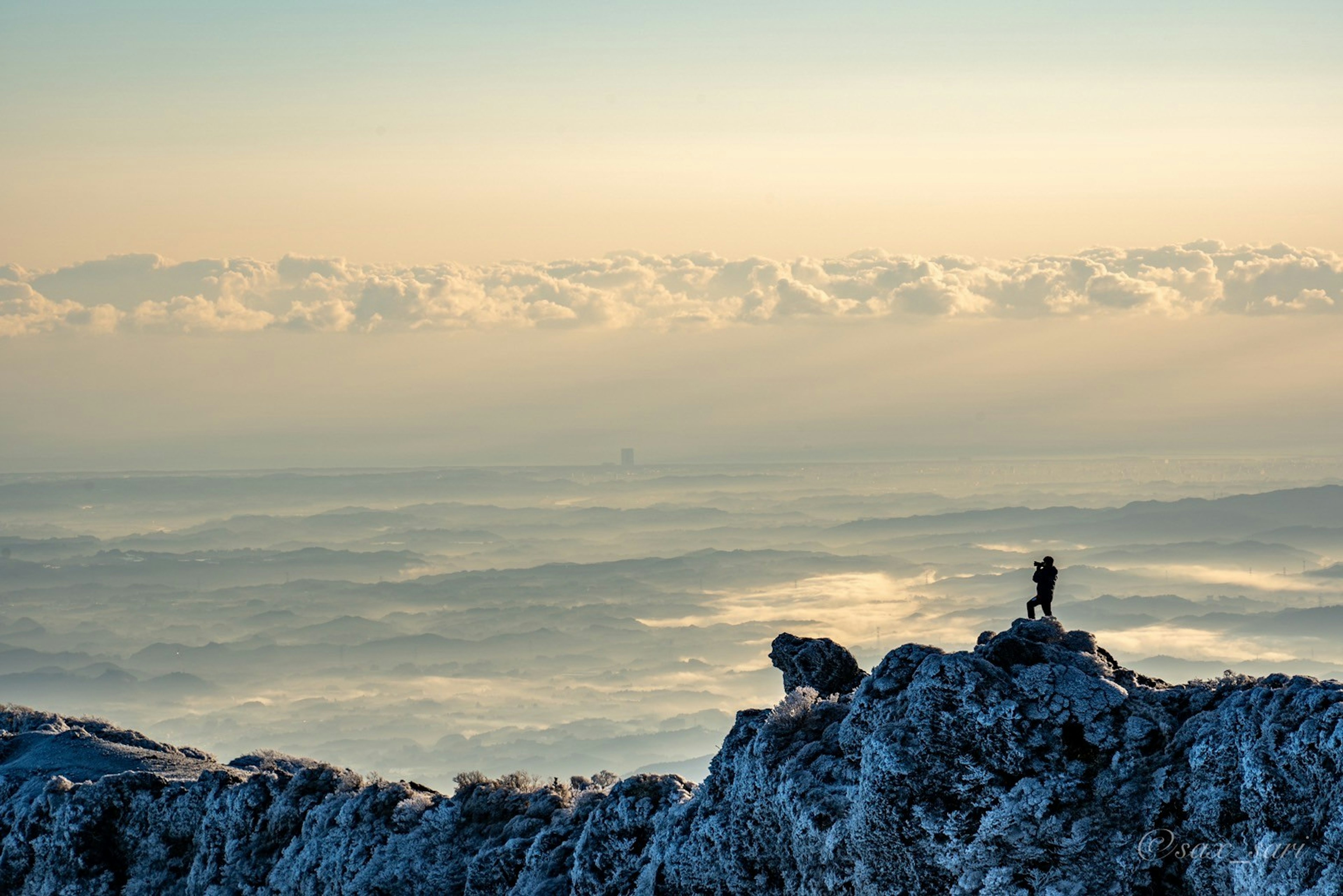 Silhouette di un climber su una vetta innevata con uno splendido sfondo di tramonto