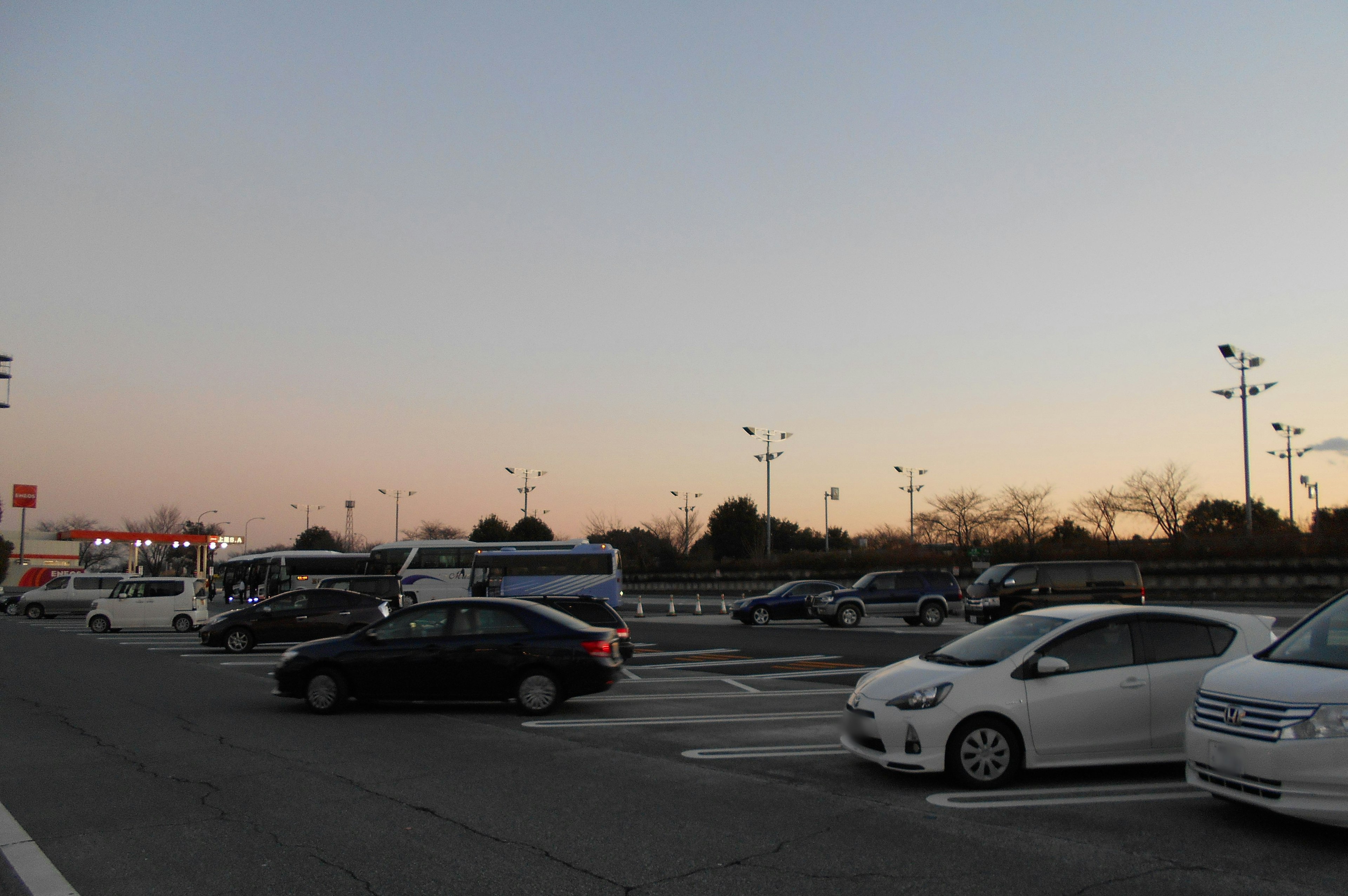 Estacionamiento al anochecer con coches estacionados