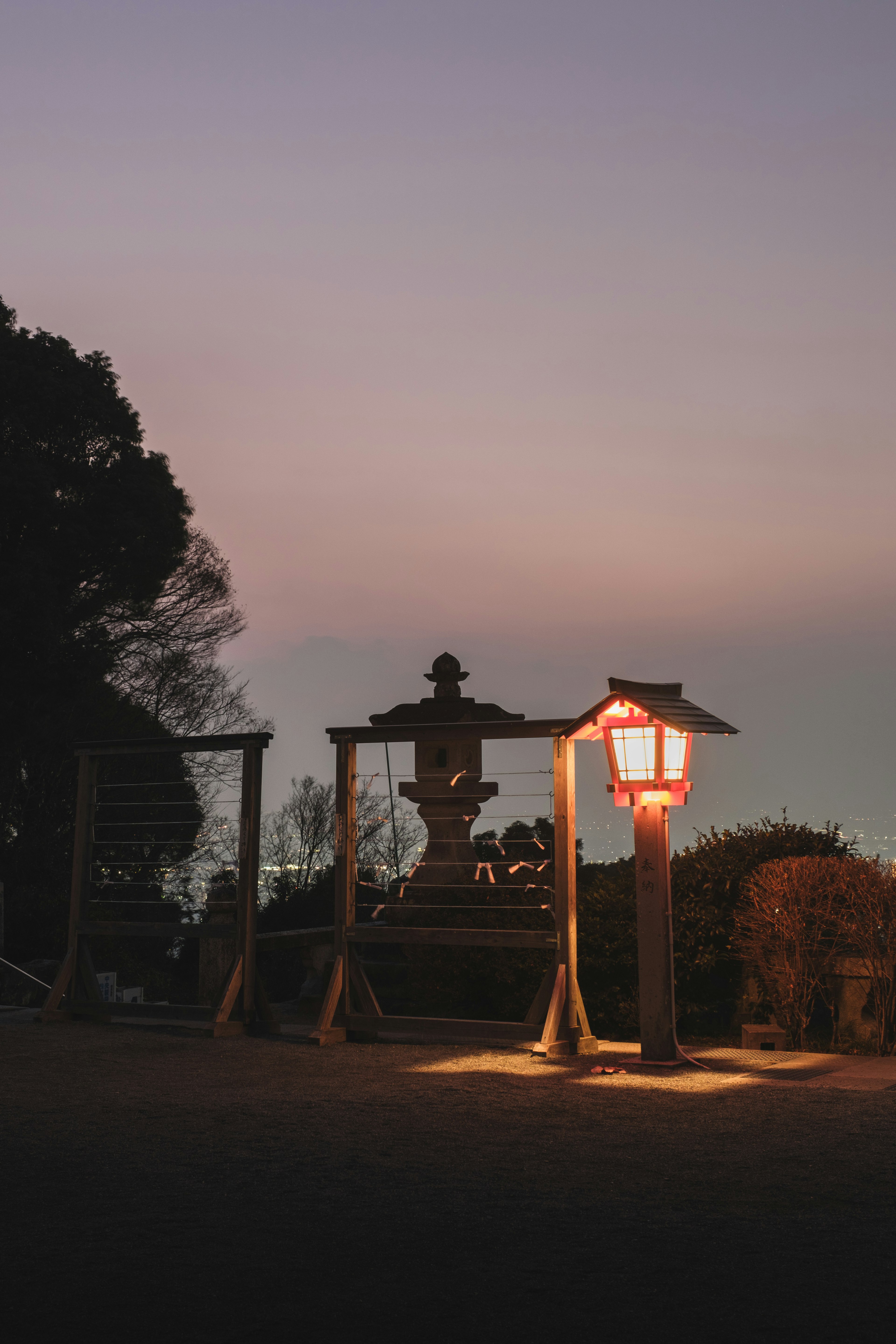 夕暮れ時の公園にある赤い灯篭と噴水