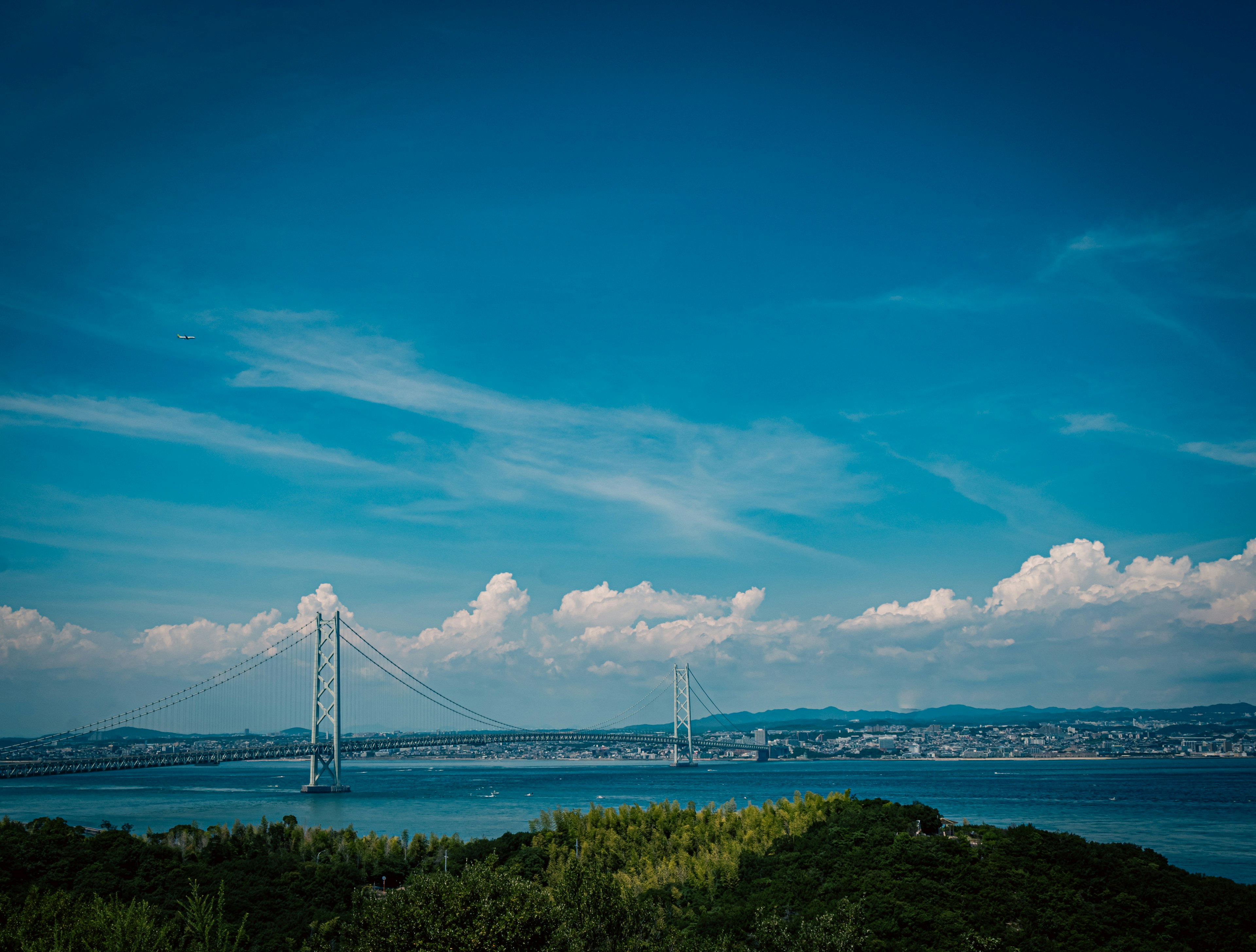 Malersicher Blick auf einen blauen Himmel mit weißen Wolken über dem Meer mit Windkraftanlagen