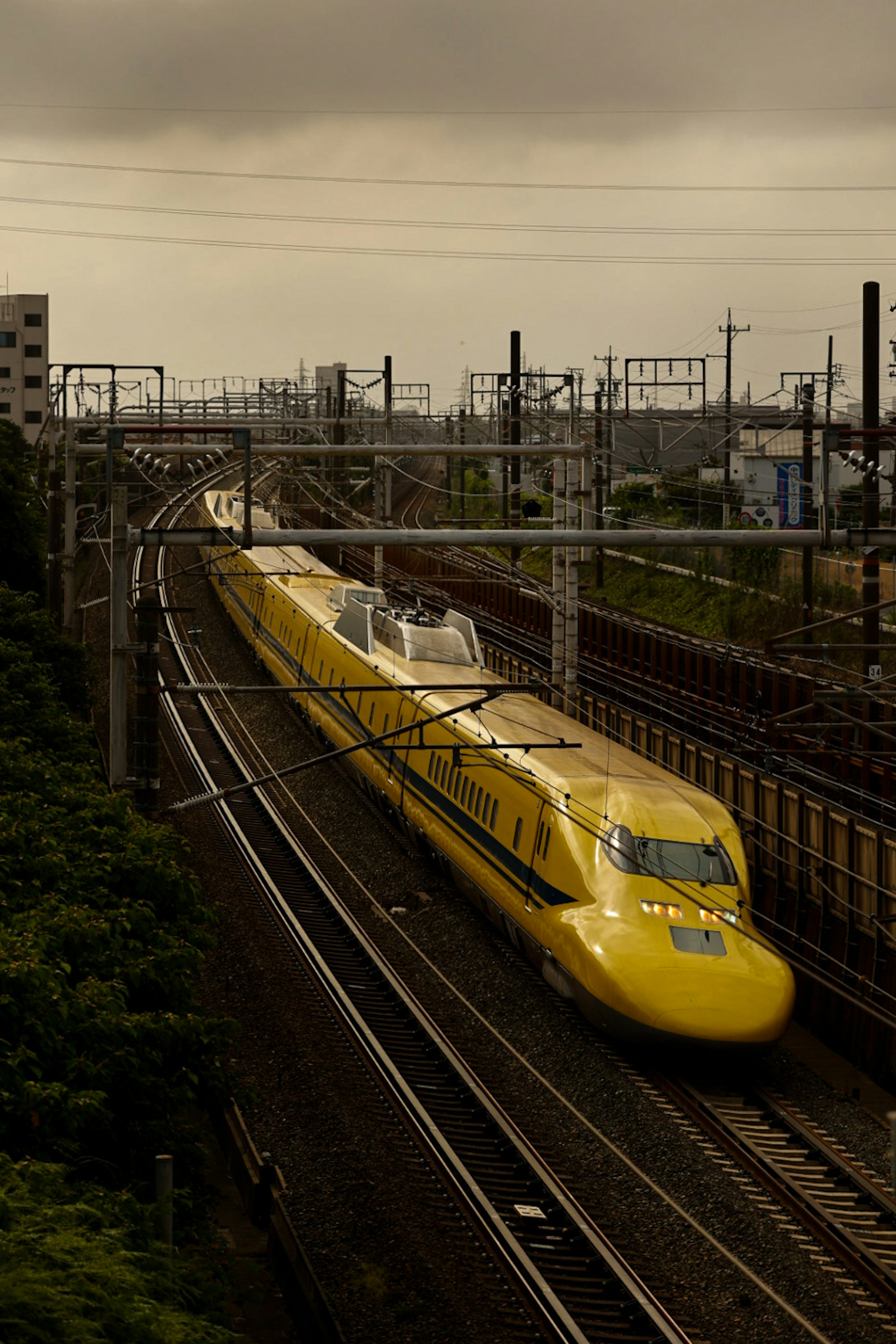 Yellow Shinkansen train traveling along the tracks