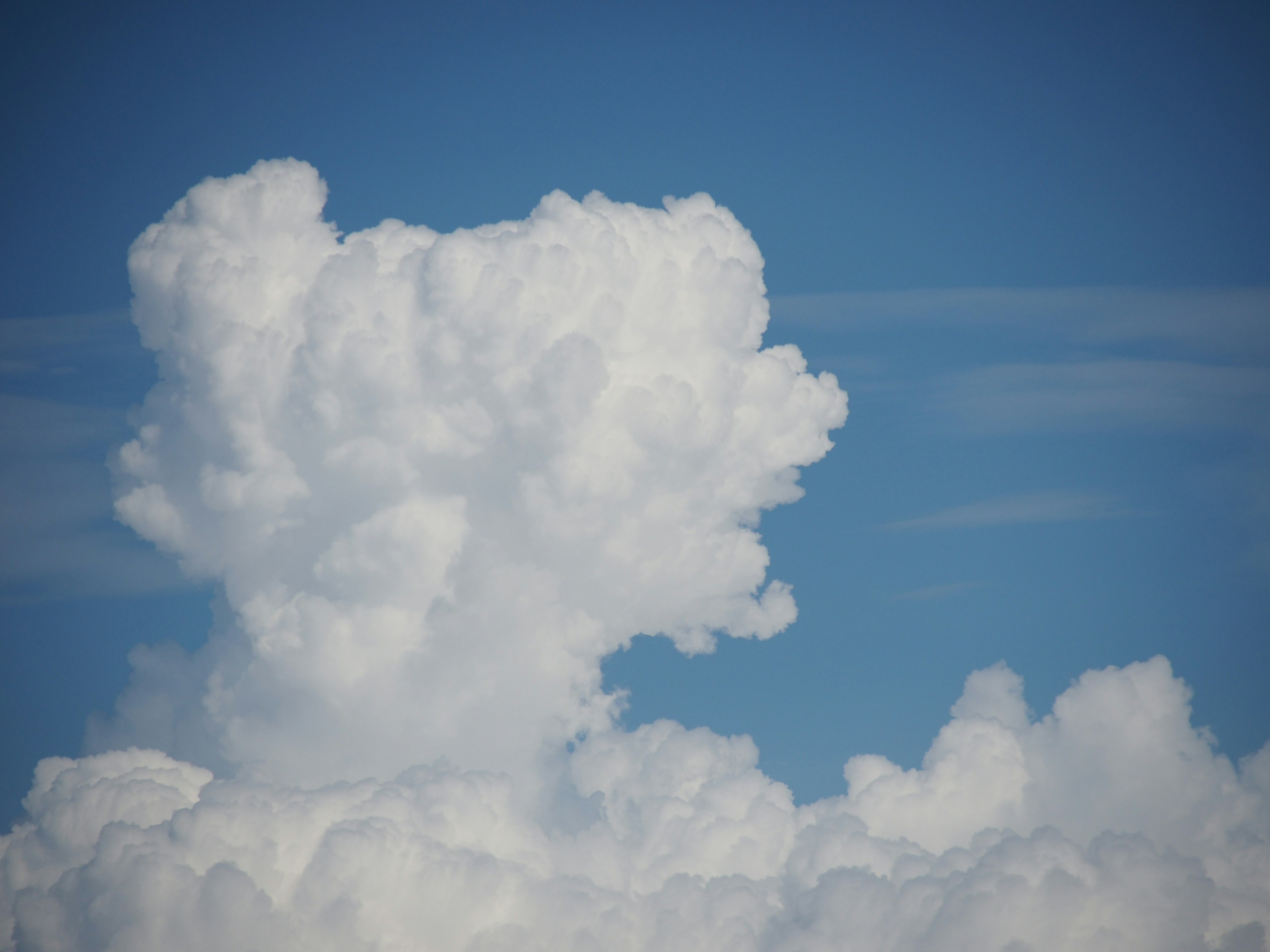 Una grande nuvola bianca e soffice contro un cielo blu