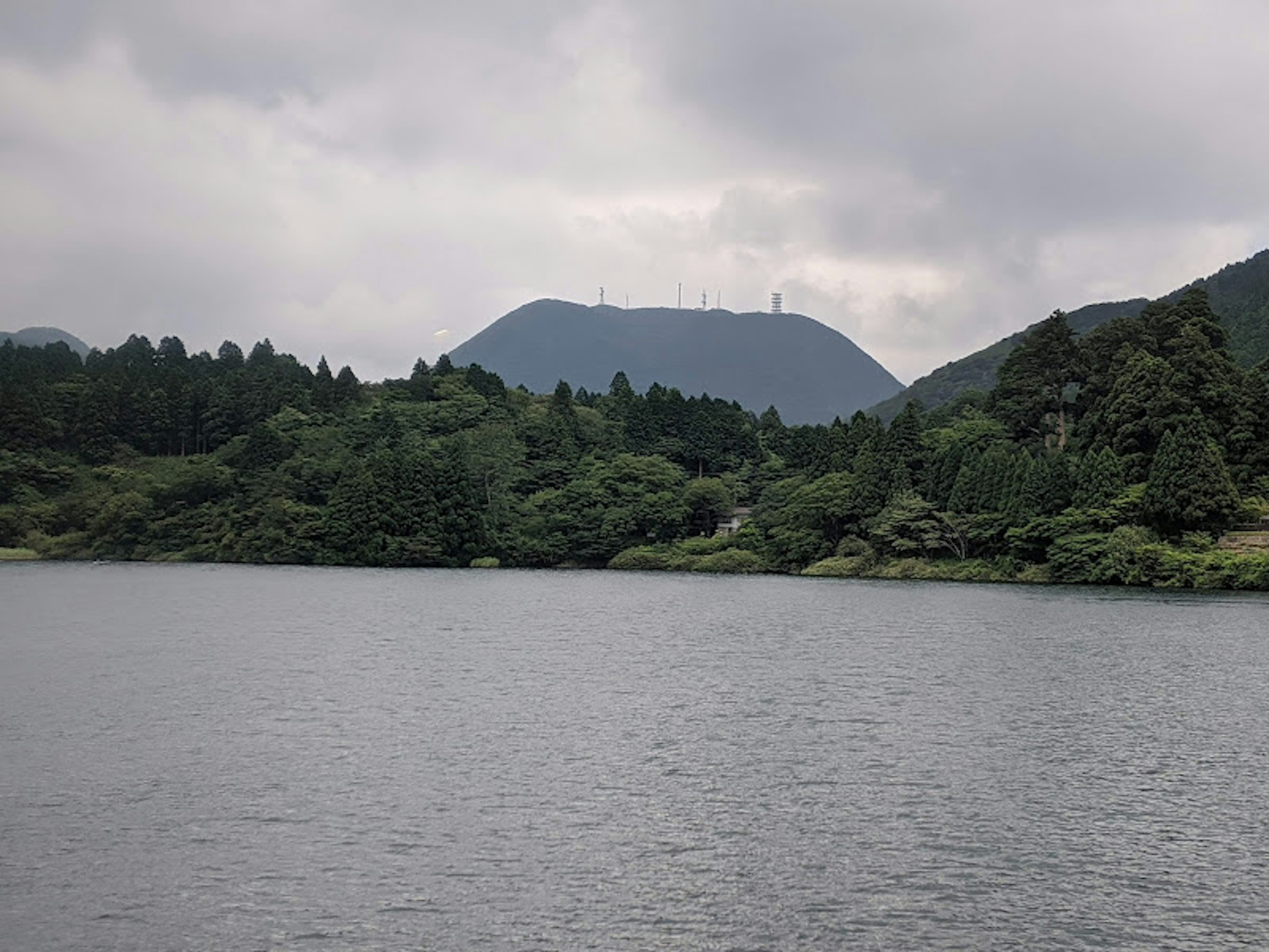 Malersicher Blick auf einen ruhigen See mit üppigen grünen Bergen im Hintergrund