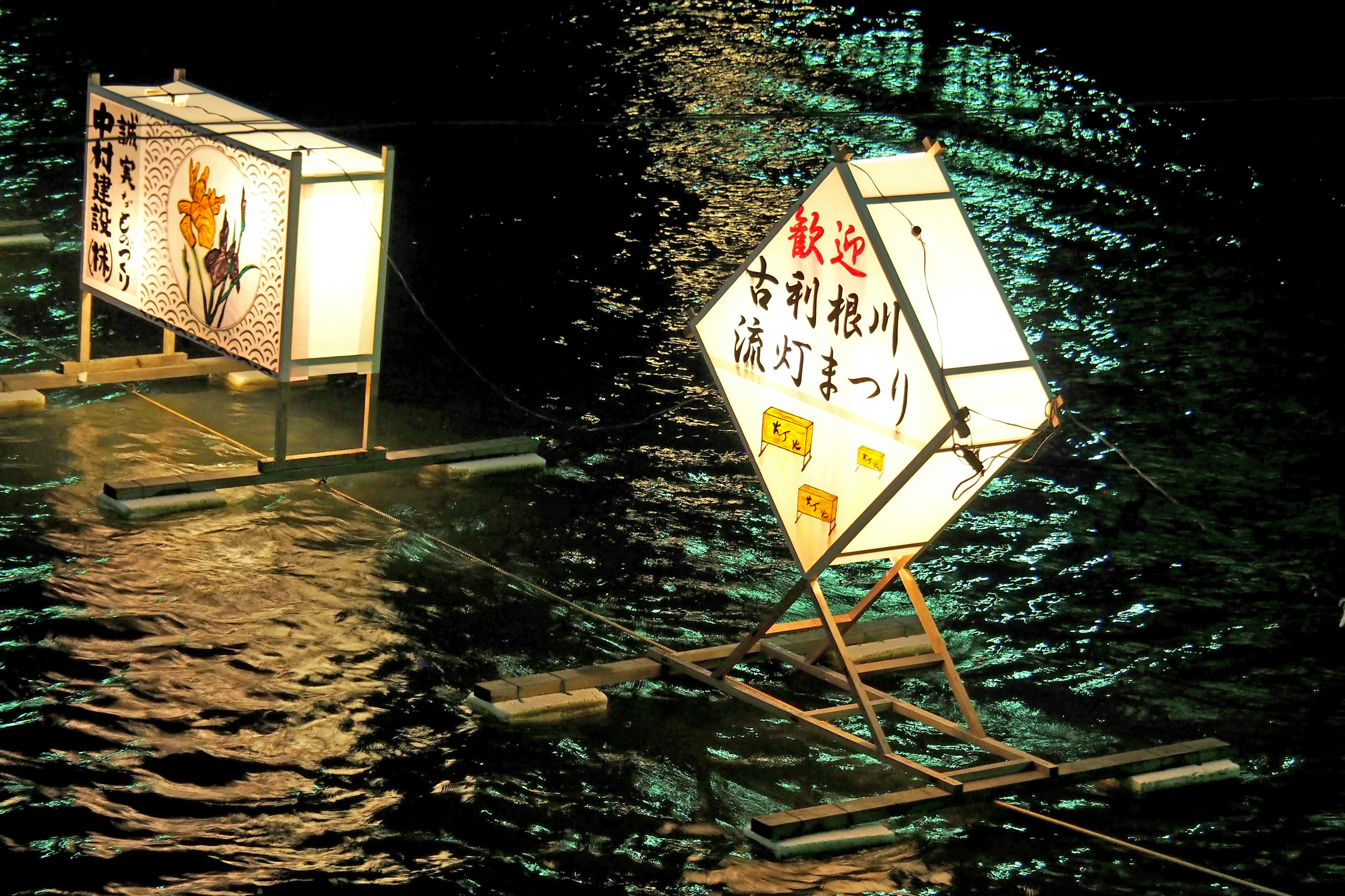 Linternas brillantes y letreros flotando en la superficie del agua