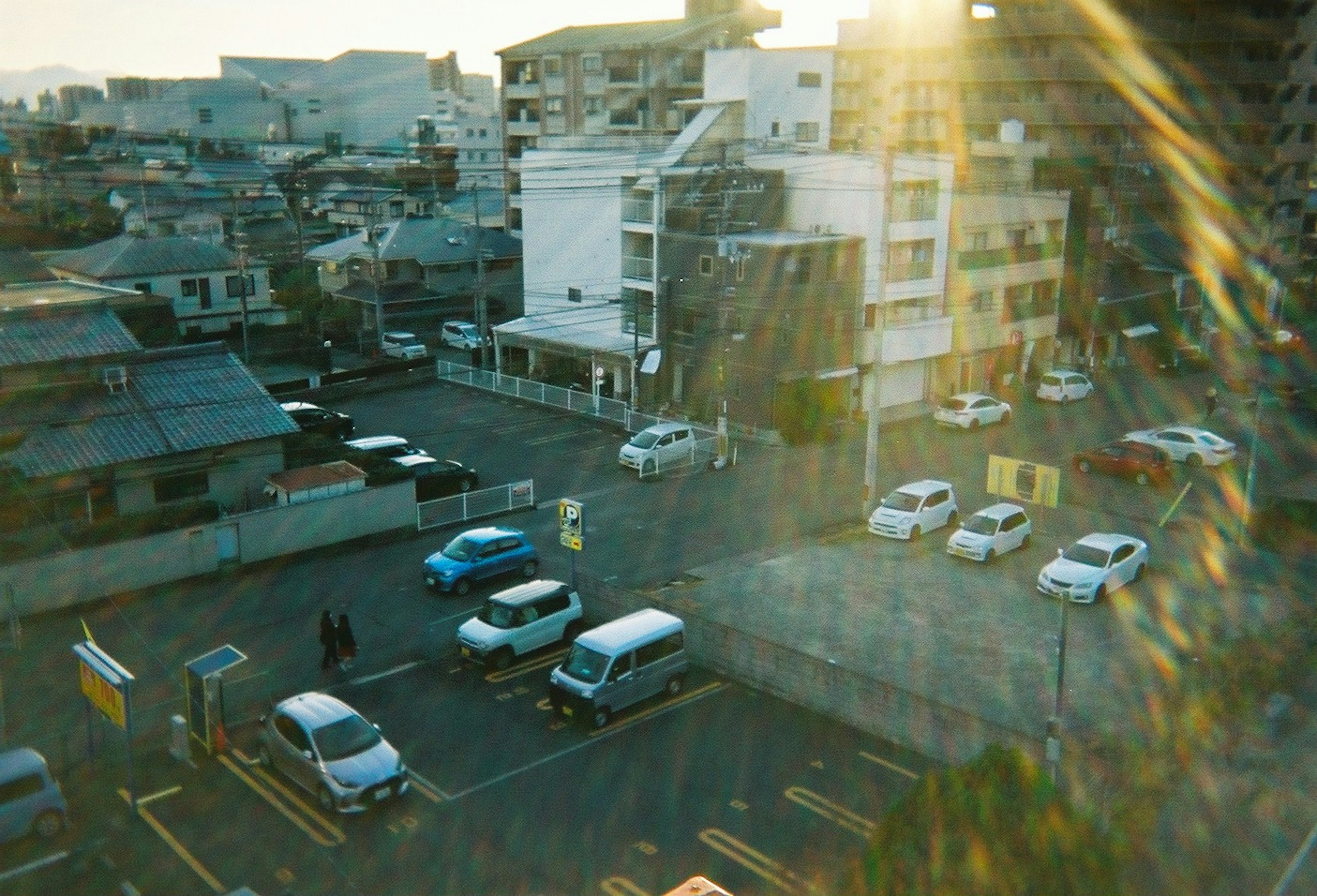 Scène d'un parking urbain avec la lumière du soleil et des voitures blanches et bleues