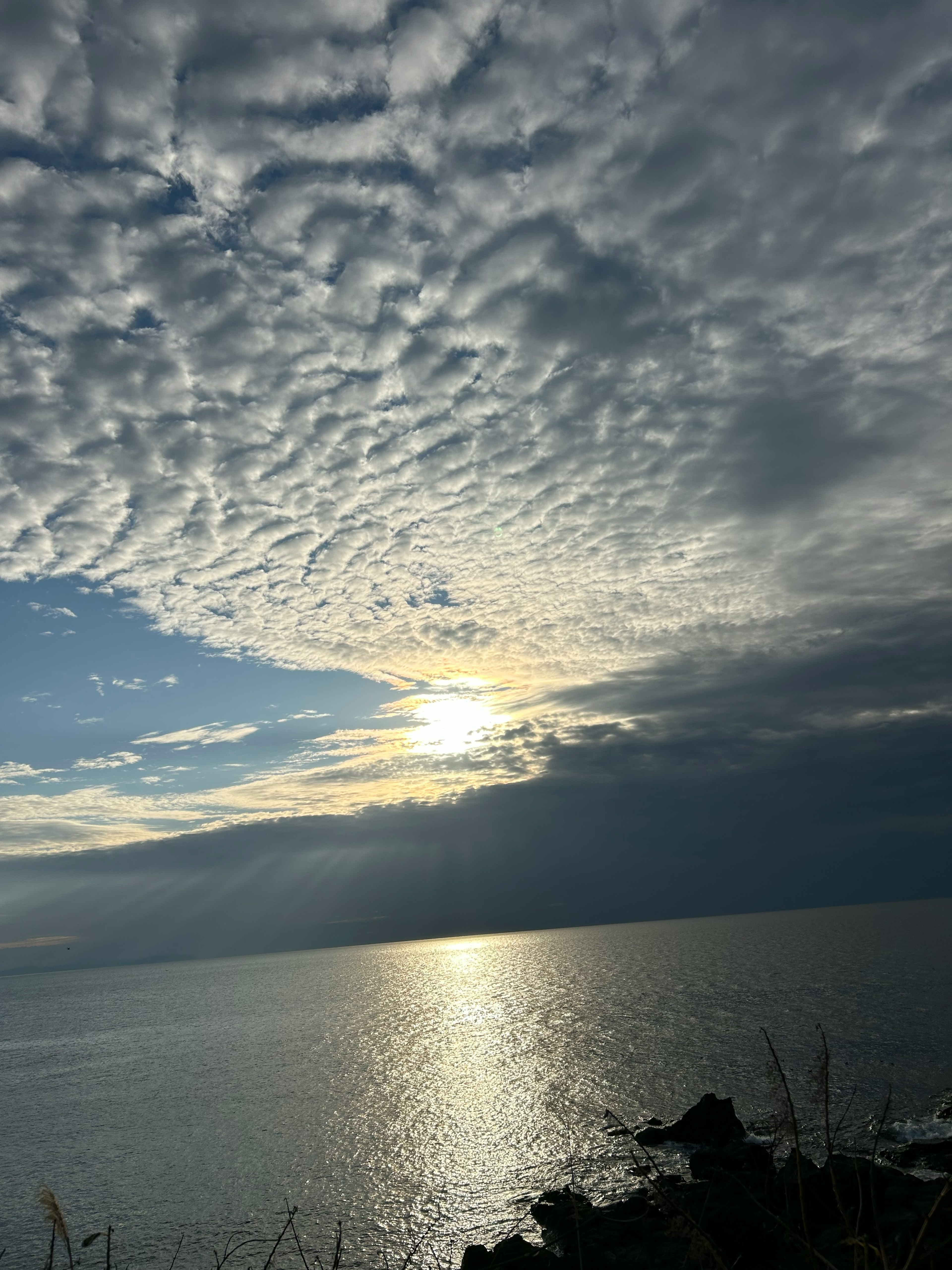 雲が広がる空と海の風景 太陽が水面に反射している