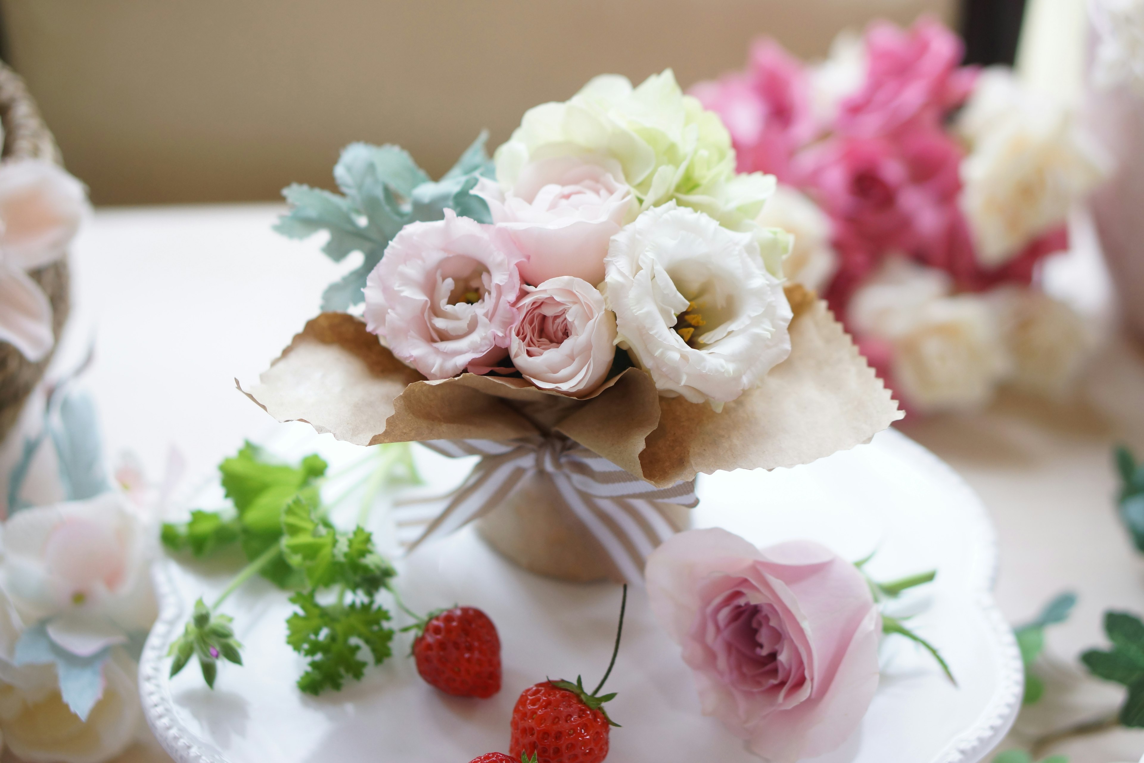 A bouquet of pastel roses with strawberries and greenery