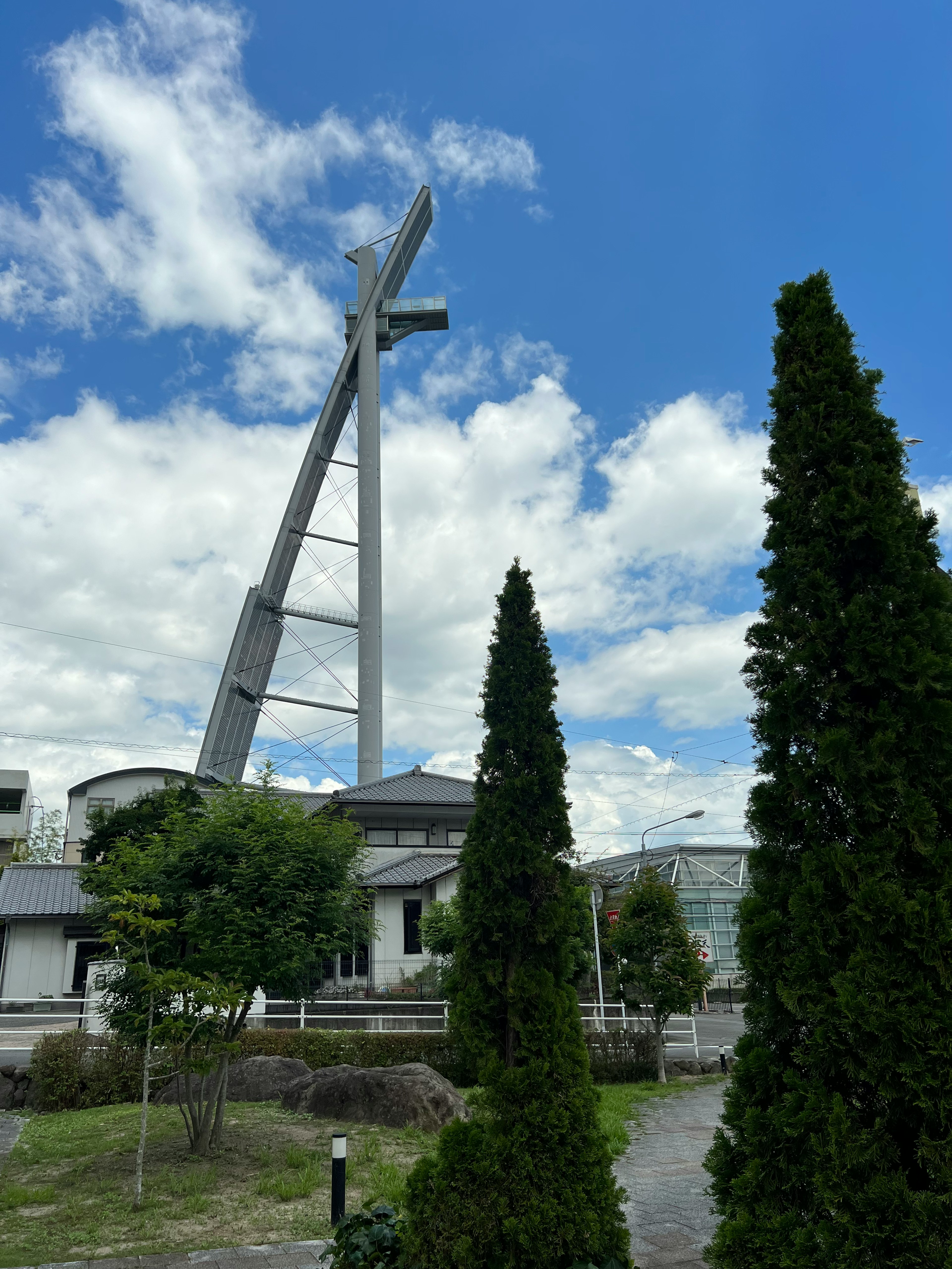 モダンなデザインの建物と高い風車が青空の下に立っている風景