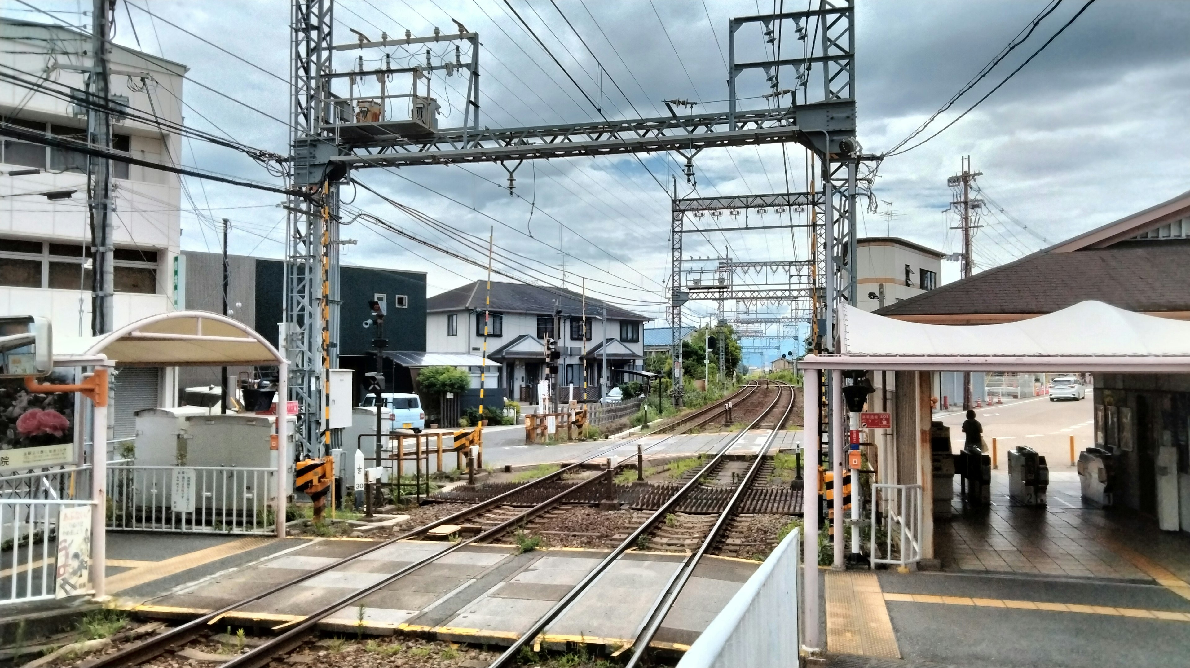 Pemandangan stasiun kereta di Jepang dengan rel dan kabel overhead