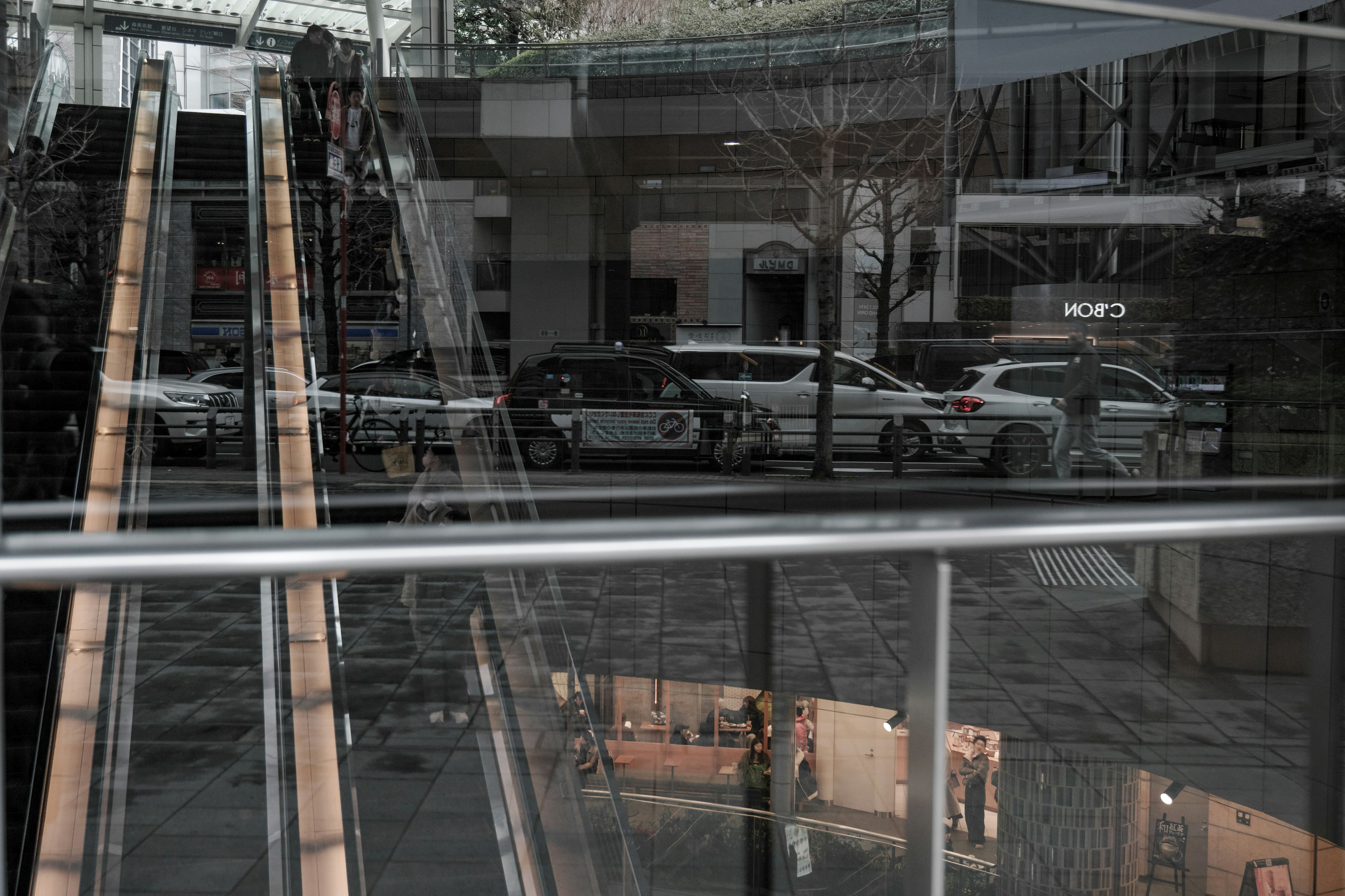 Reflejo de vehículos policiales y escaleras mecánicas en un espacio comercial moderno