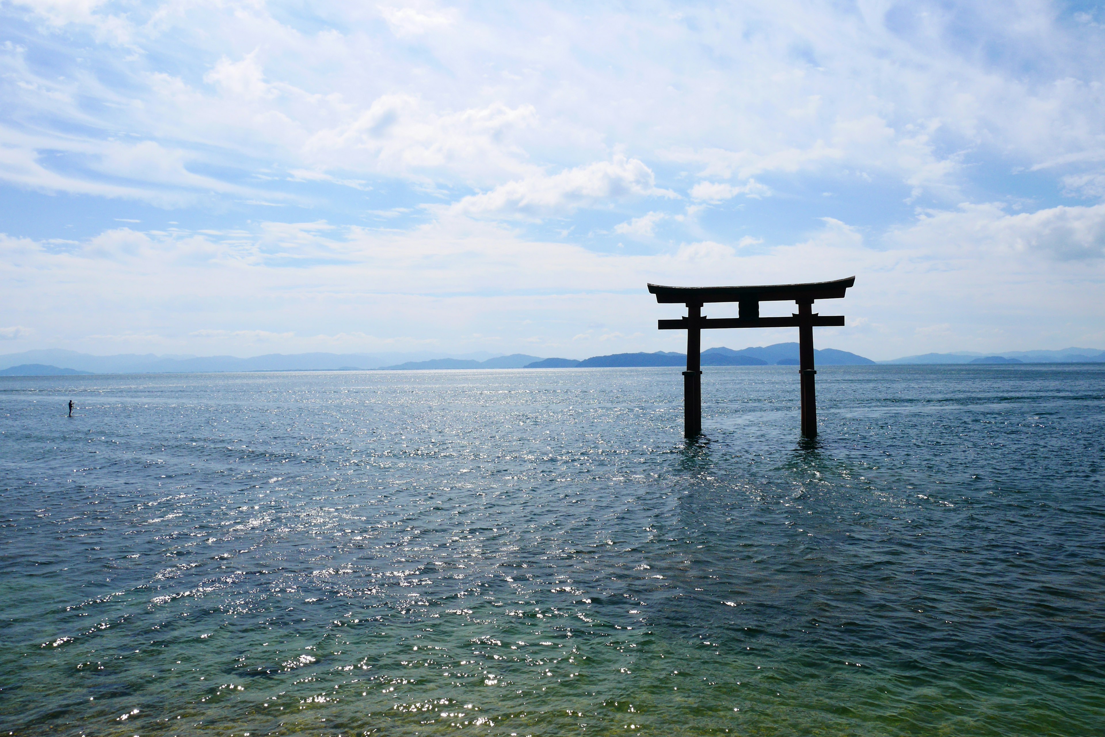 Portale torii che si erge nel mare blu sotto un cielo luminoso