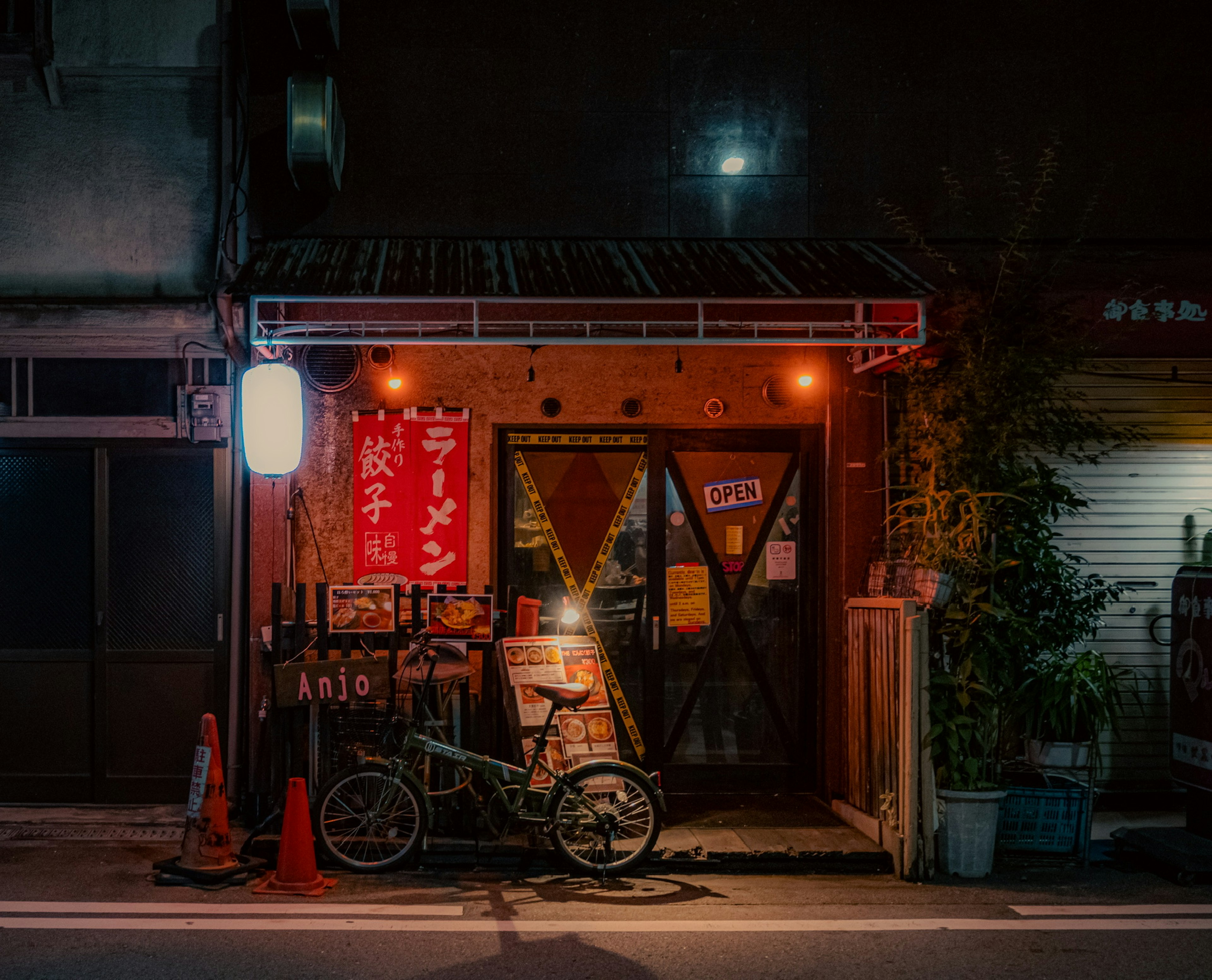 Außenansicht eines japanischen Restaurants bei Nacht rote Beschilderung und orange Beleuchtung