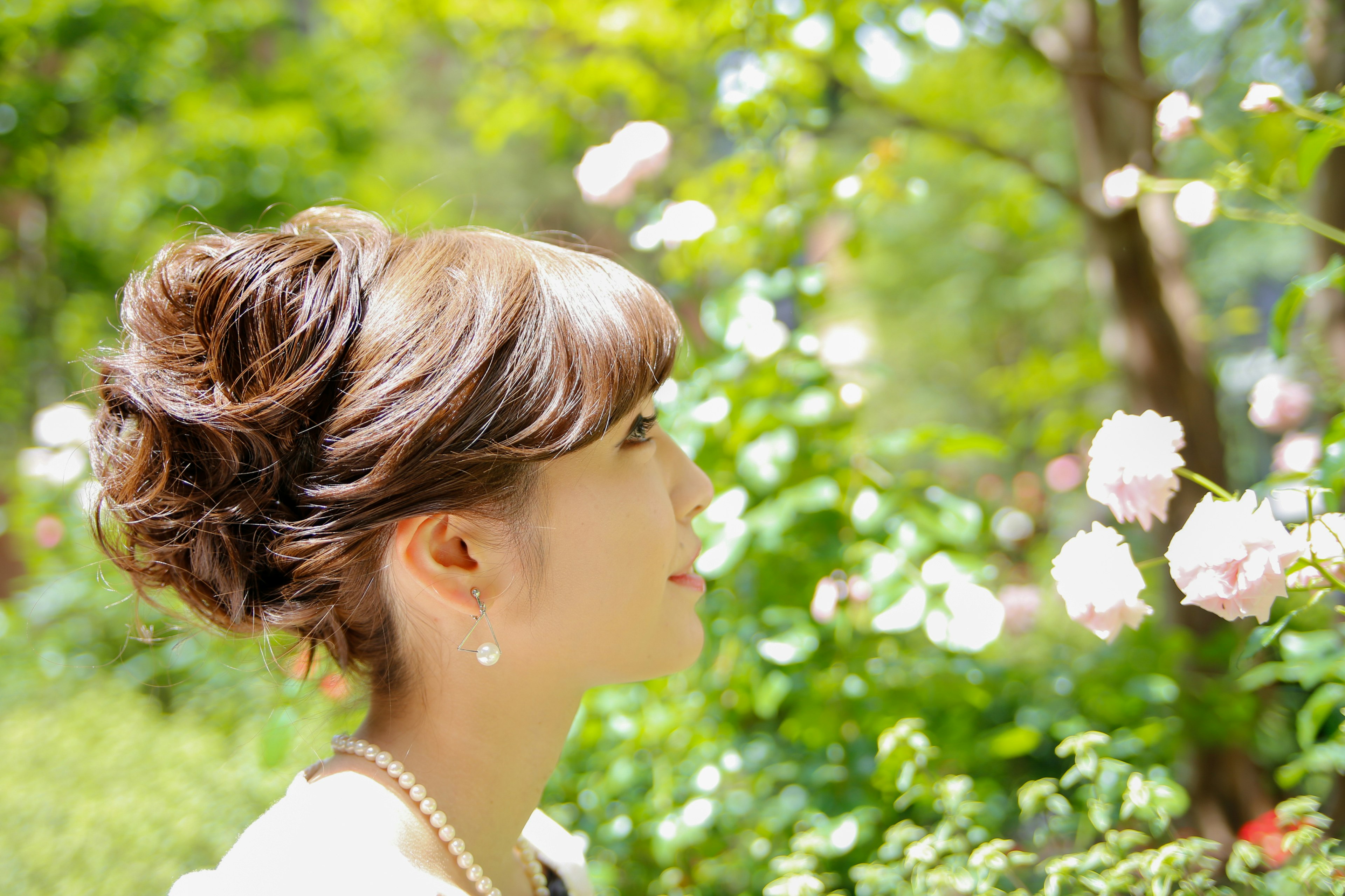 Perfil de una mujer sonriendo frente a hermosas flores