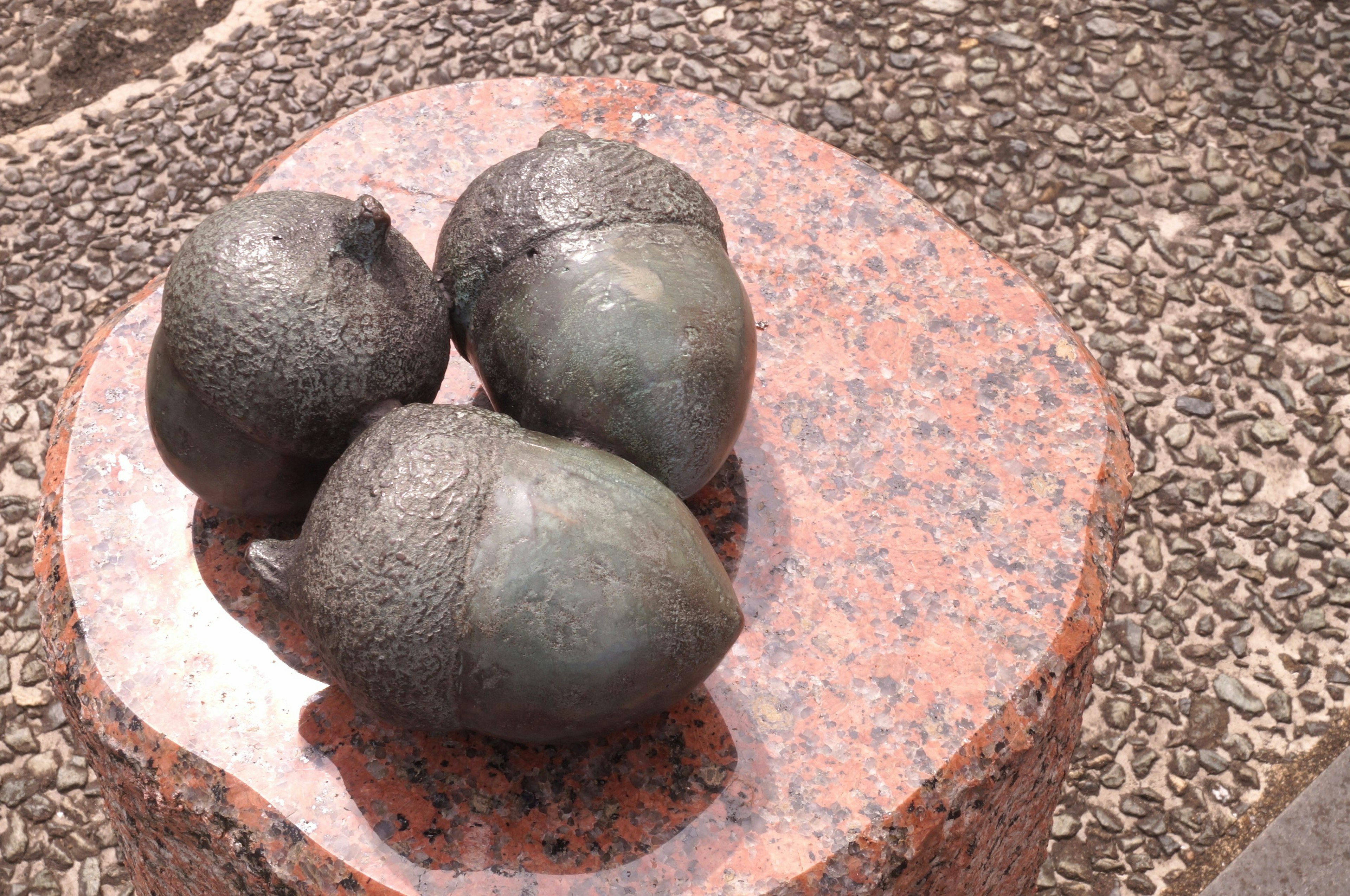 Three metallic sculptures placed on a stone pedestal