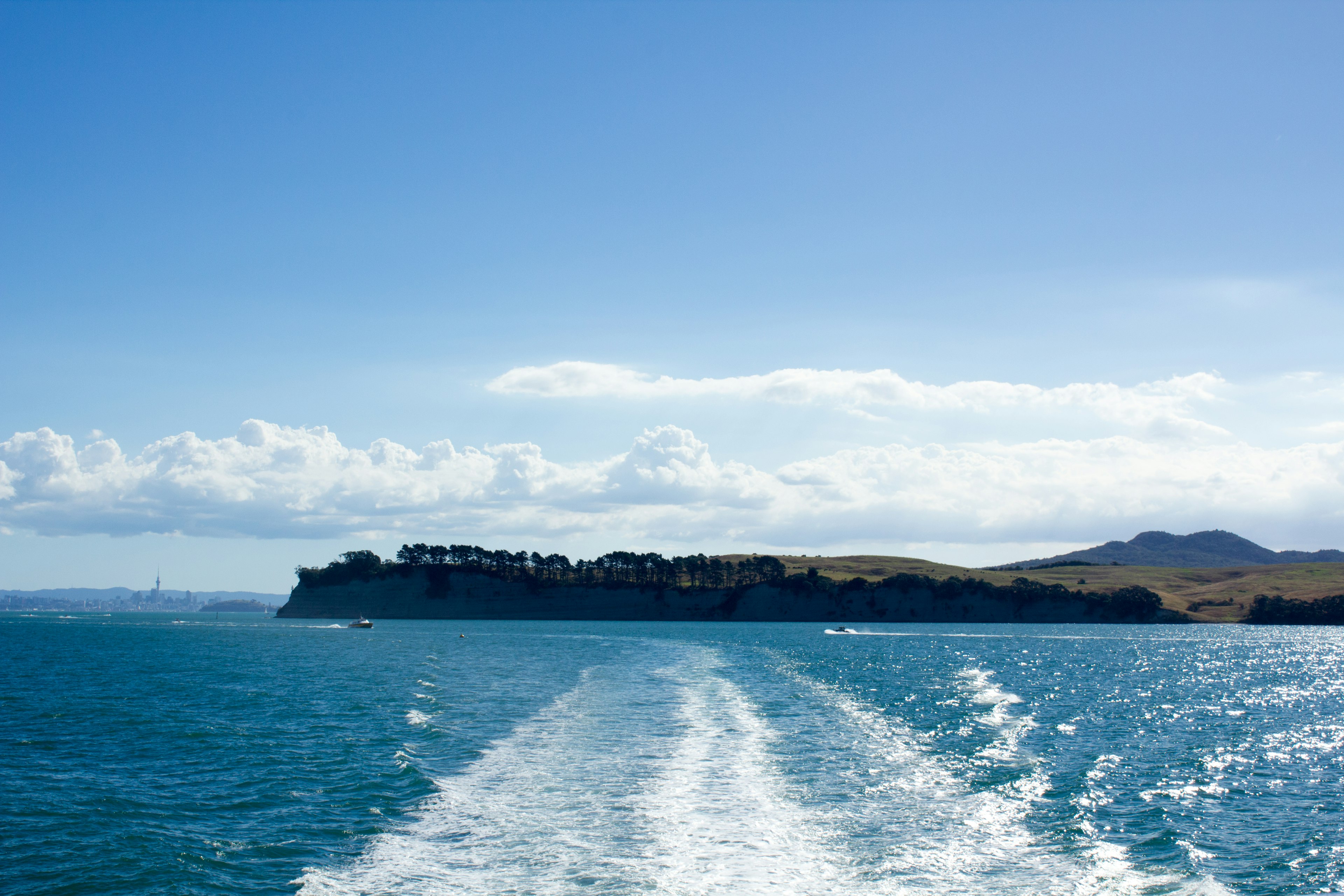 Vista del mar azul y el cielo con la estela de un barco