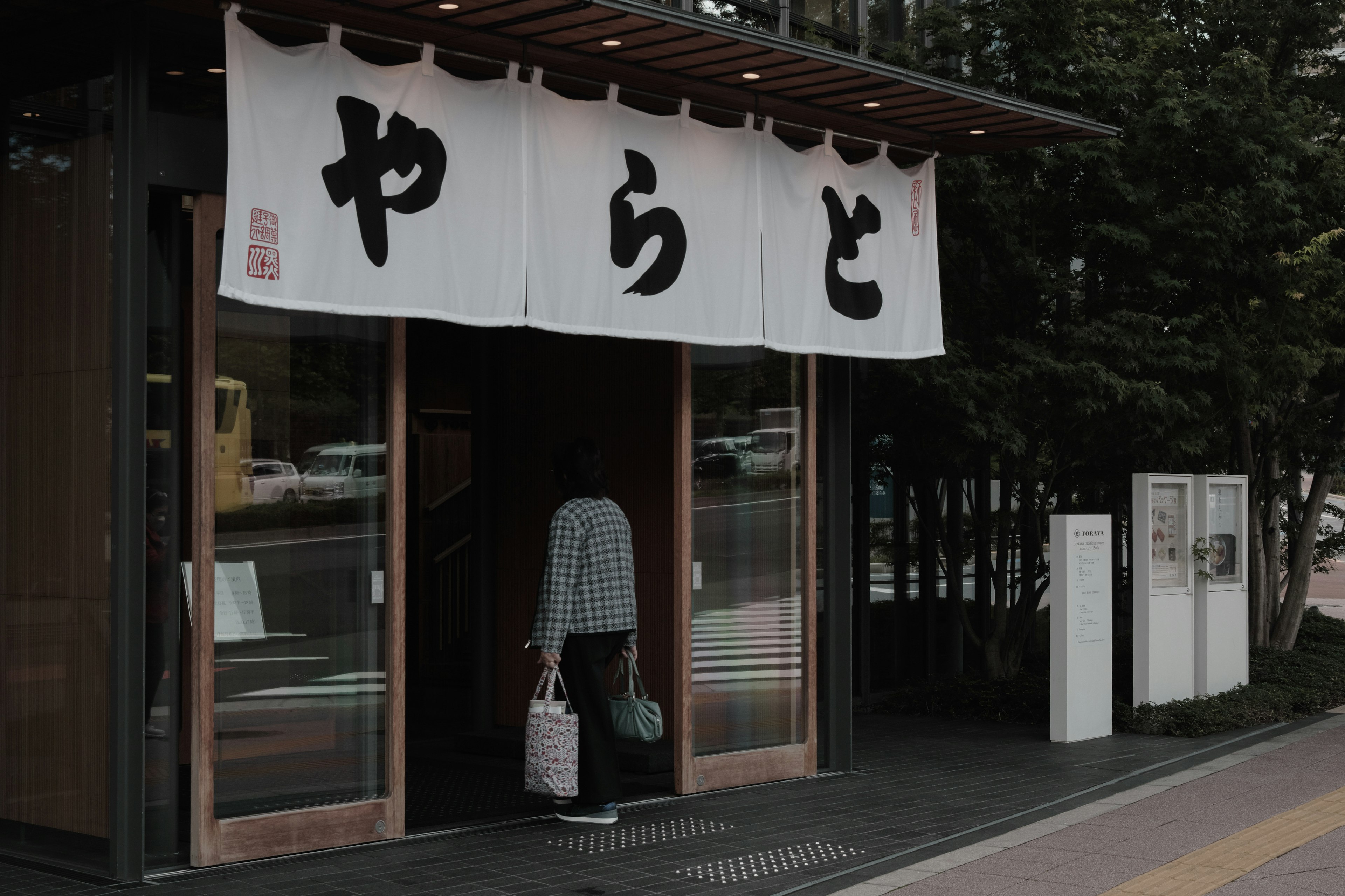 Entrada de un restaurante con el nombre YARADO y una persona entrando