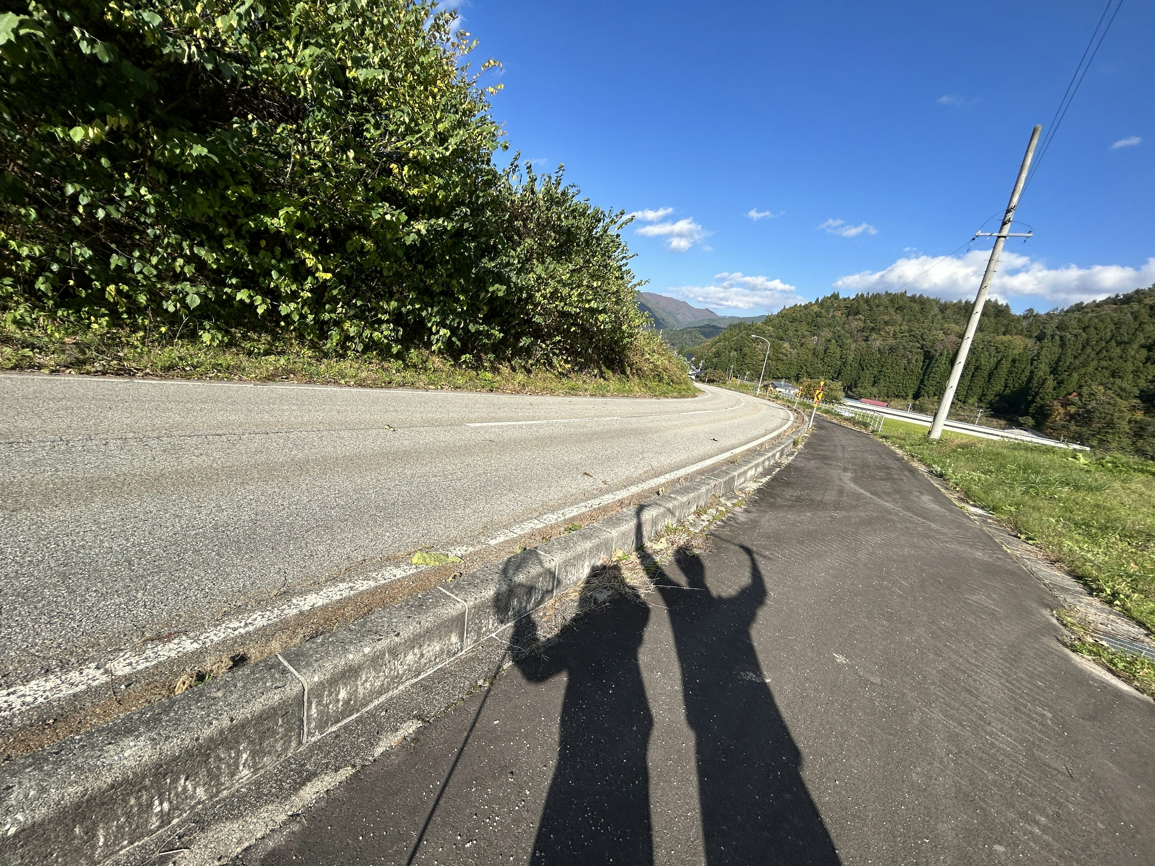 山の風景を背景にした道路の影