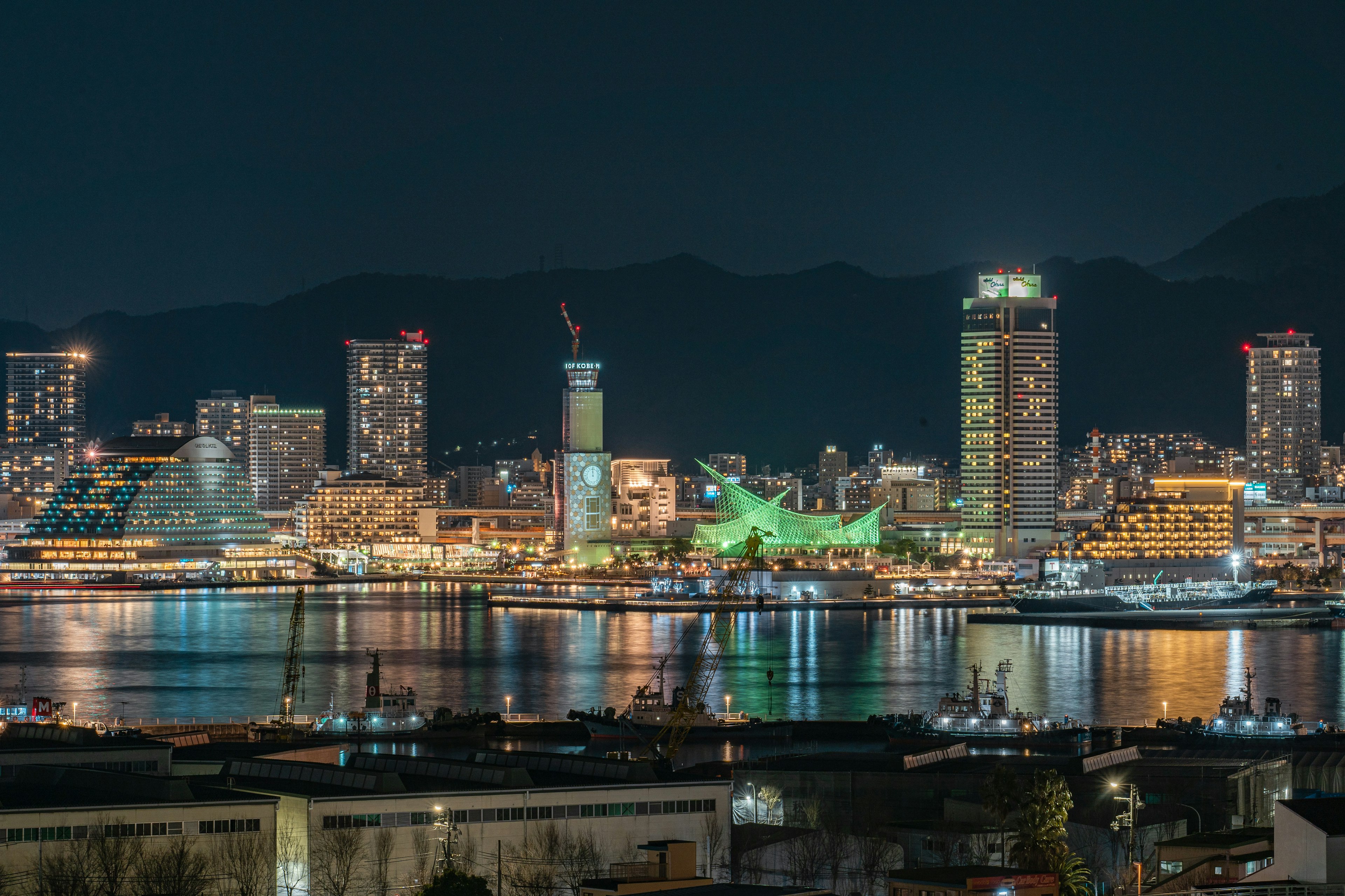 Vista nocturna del horizonte de Kobe con edificios iluminados