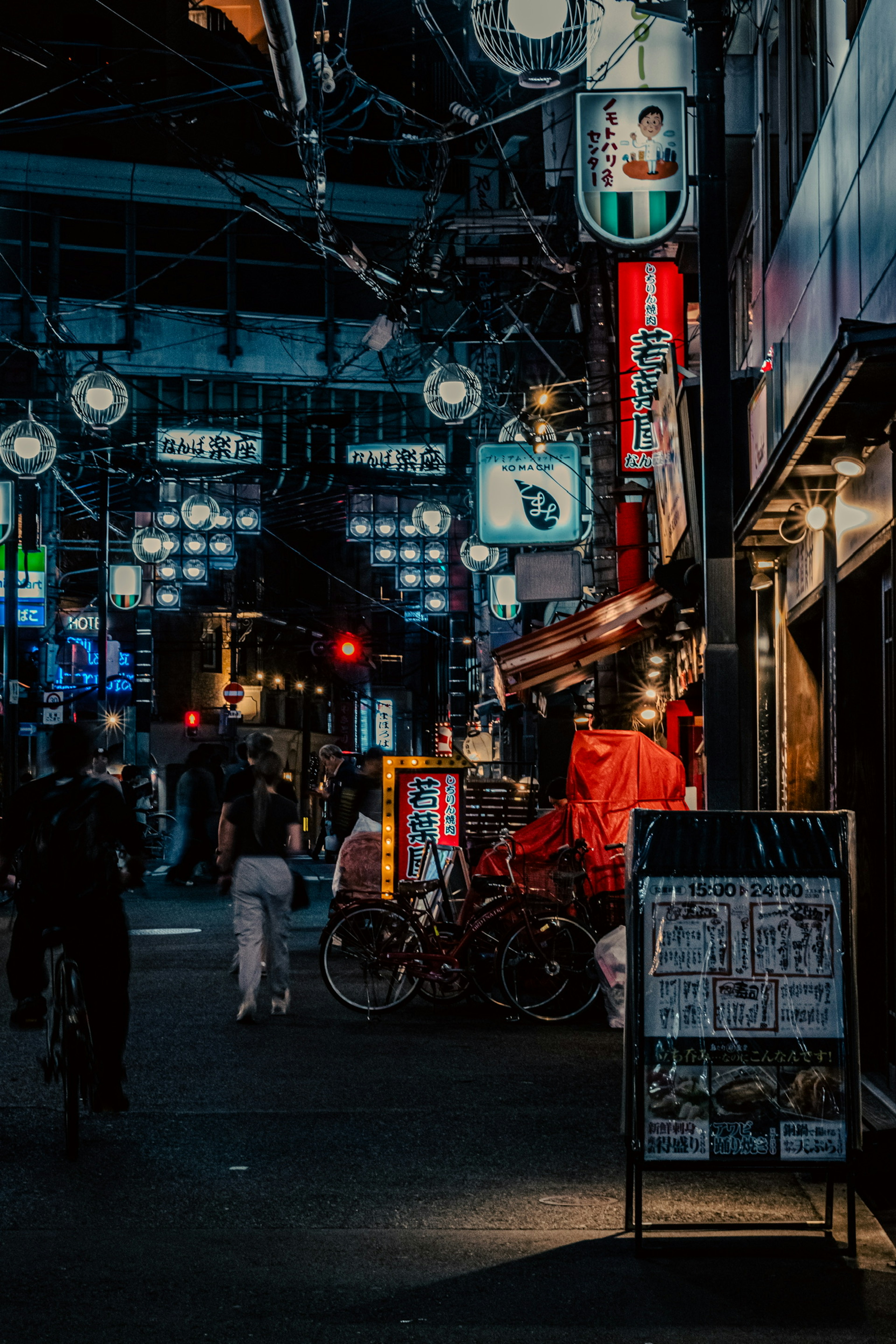 Calle concurrida de noche en Japón con gente y bicicletas