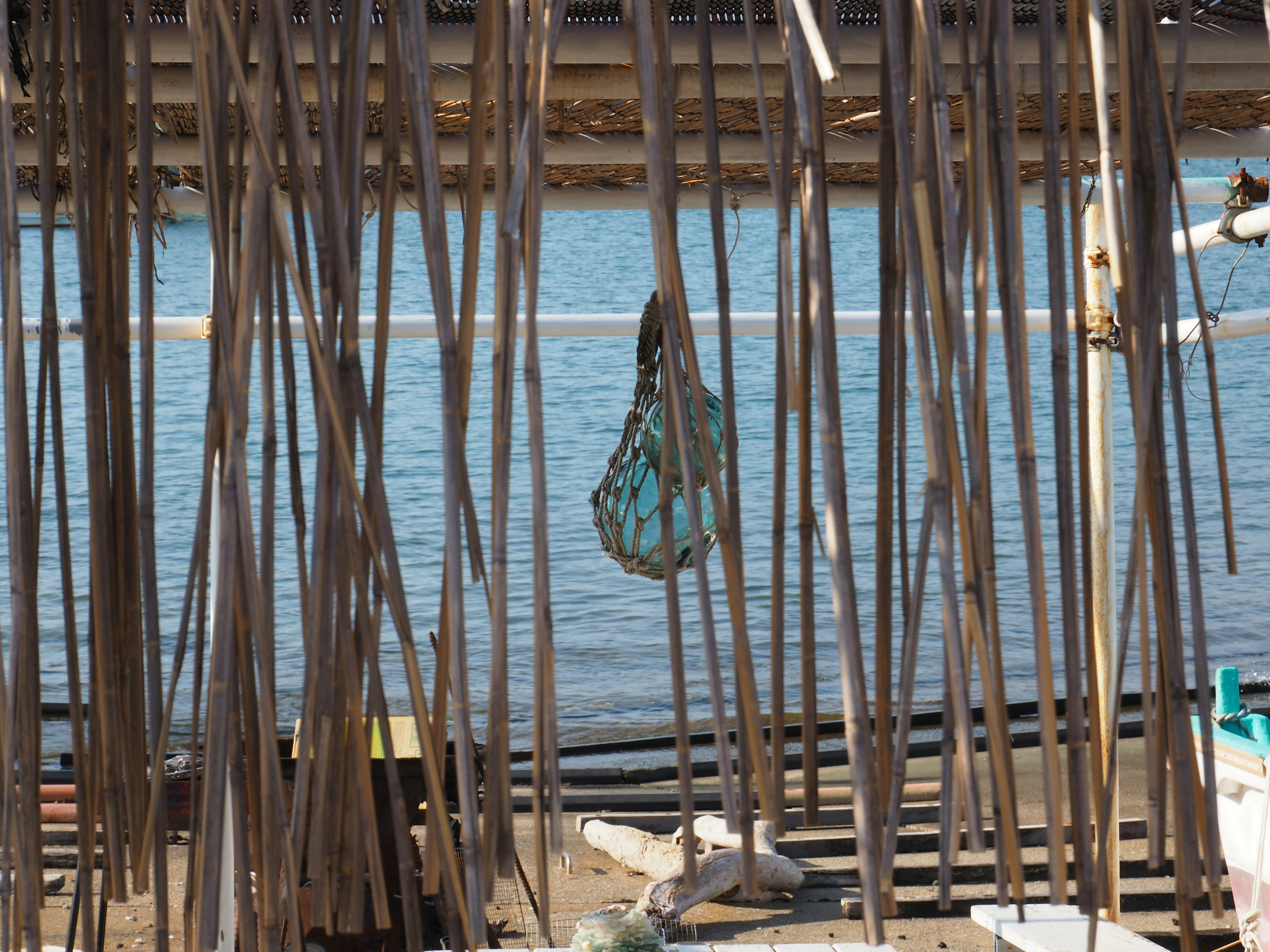 Bolsa verde colgando cerca del agua con varillas verticales delgadas