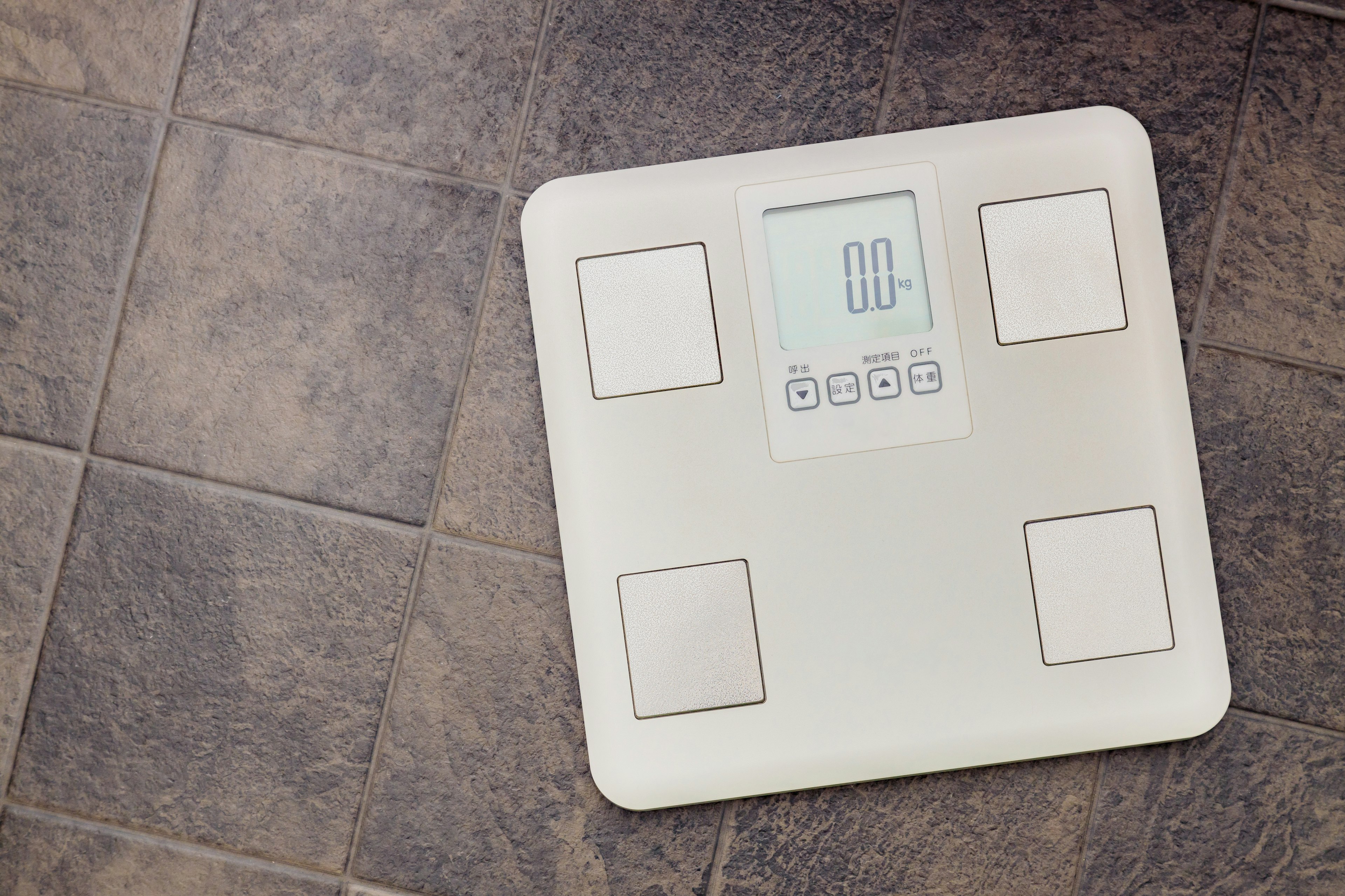 Digital weighing scale placed on tiled floor