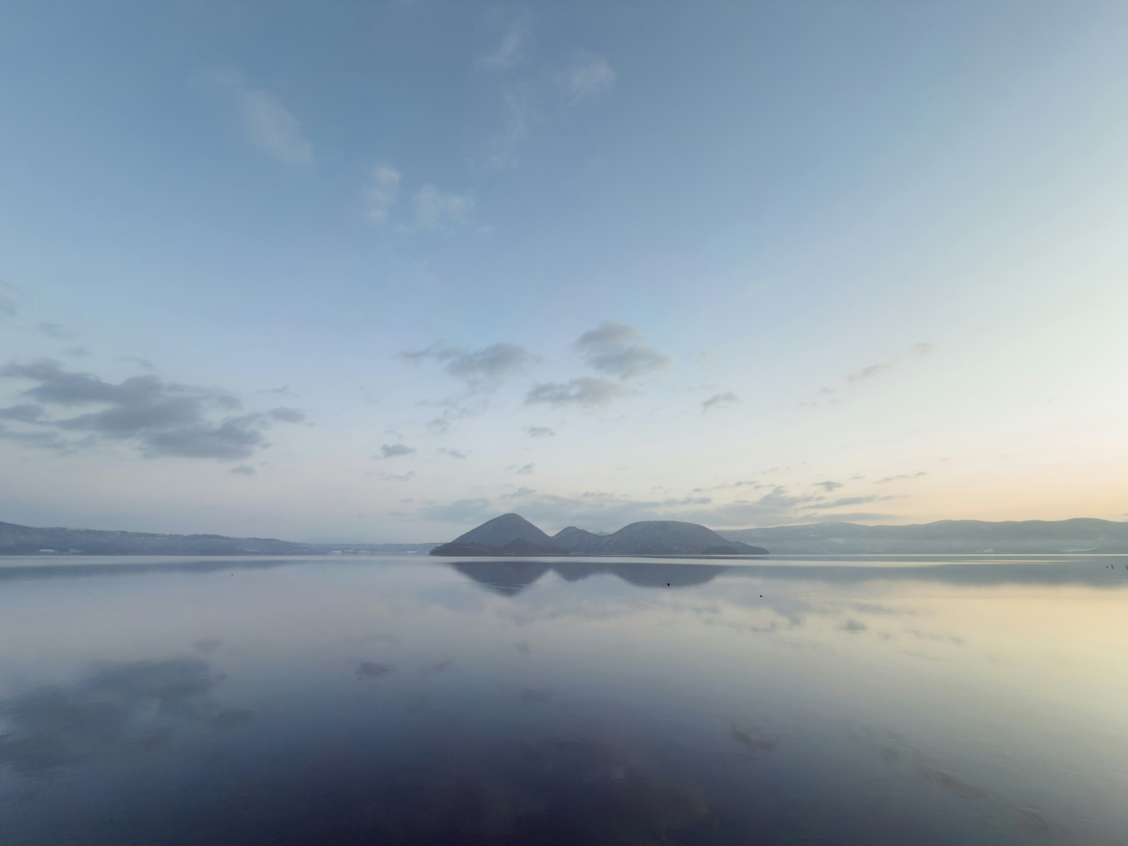 Serene landscape with mountains and sky reflected on calm water