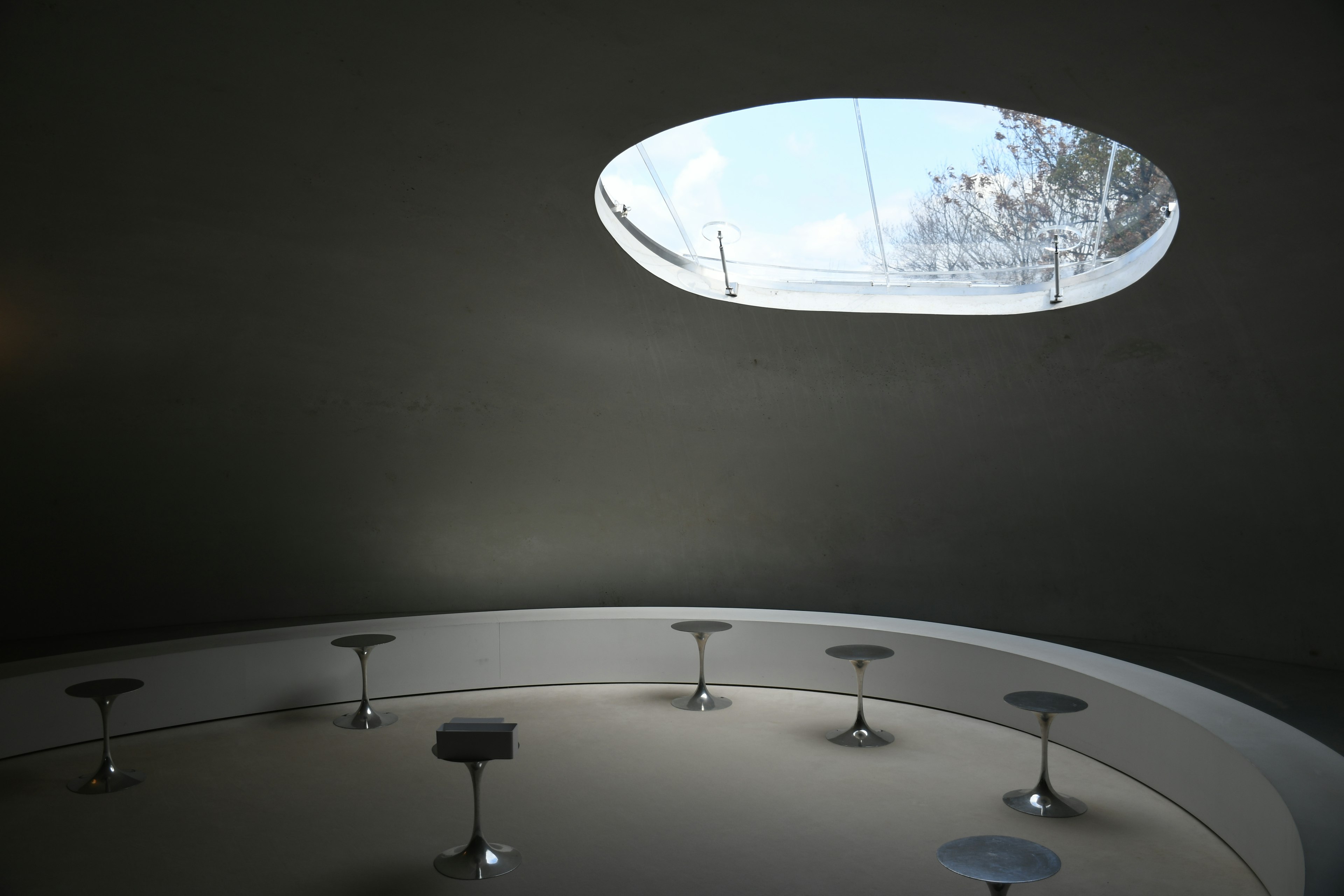 Stylish interior design space with natural light from an oval window circular counter and steel stools